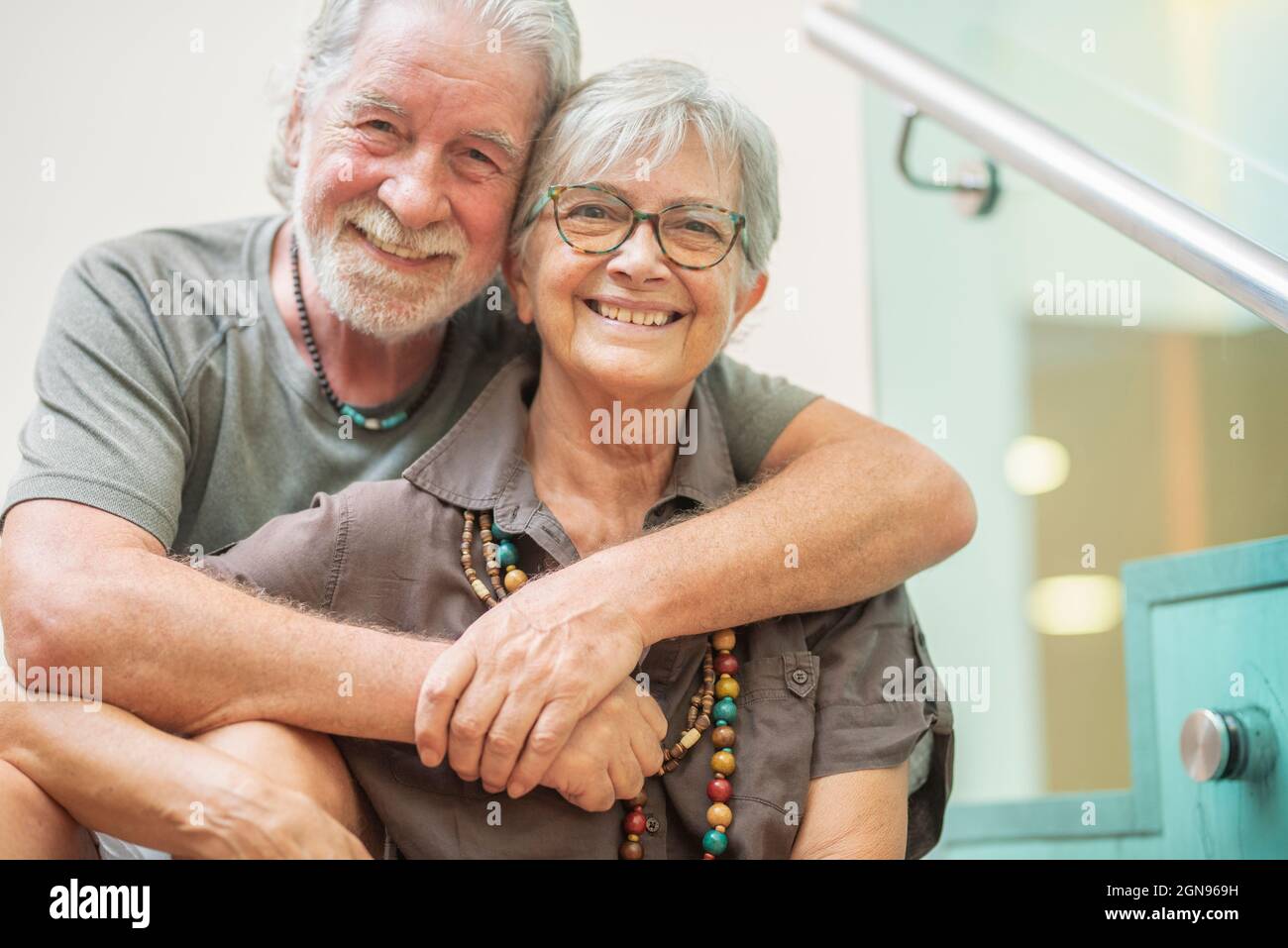 Couple senior heureux avec cheveux gris assis ensemble Banque D'Images