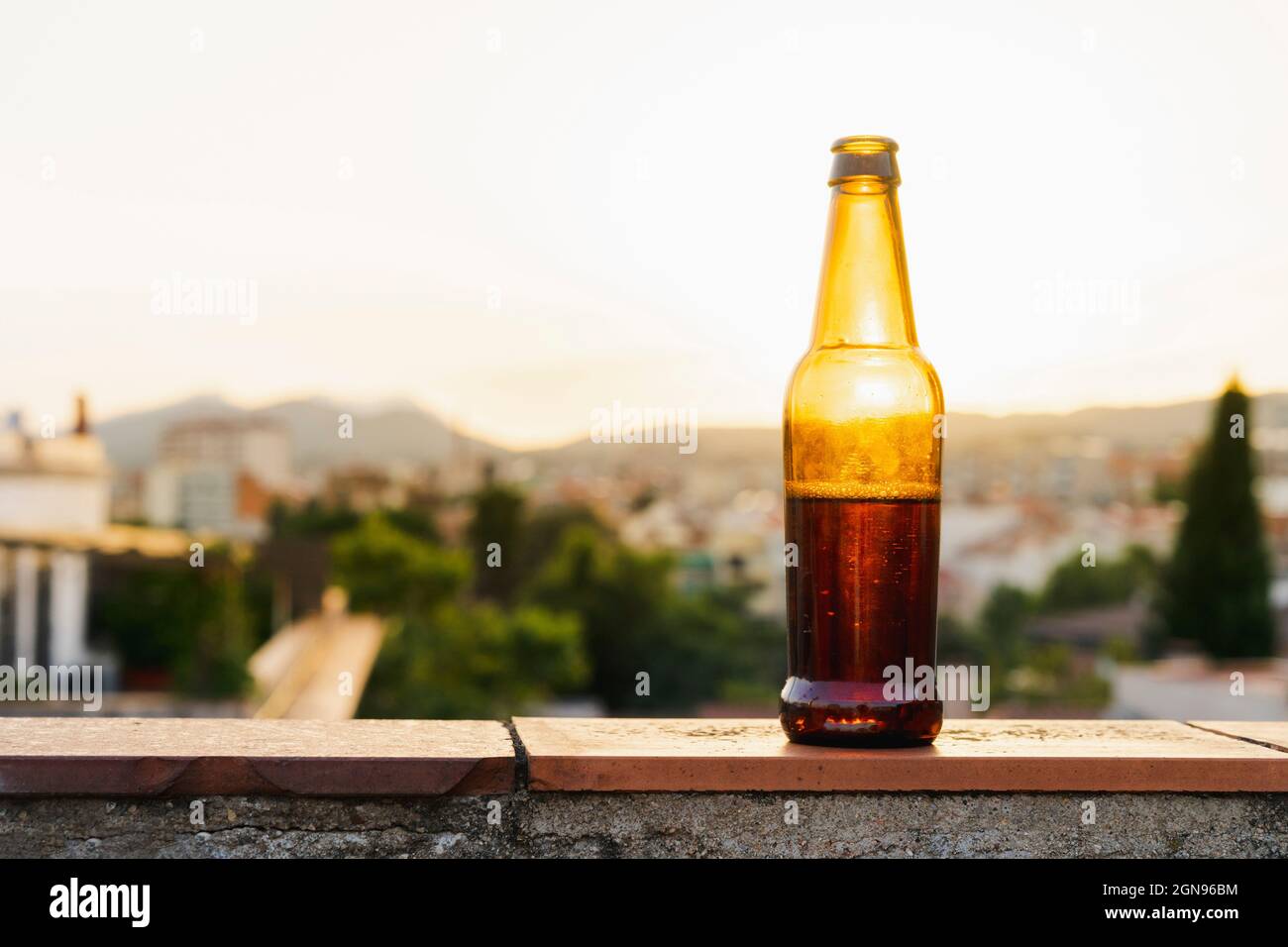 Bouteille de bière sur le mur de soutènement pendant le coucher du soleil Banque D'Images