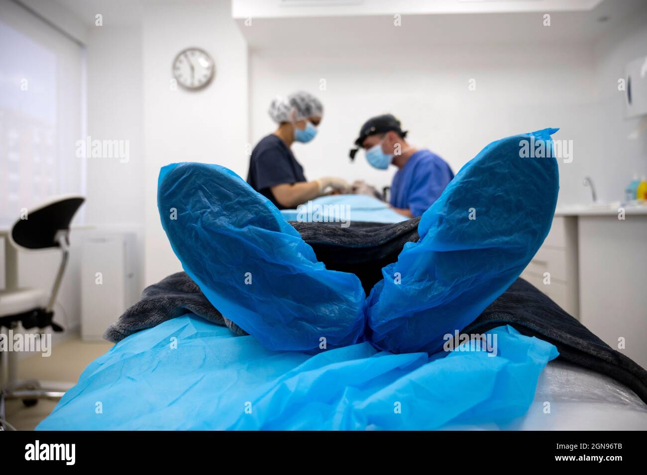 Le chirurgien suture la paupière après une opération de chirurgie plastique Banque D'Images