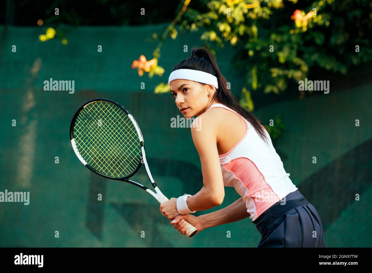 Une joueuse de tennis tient une raquette sur un terrain de sport Banque D'Images