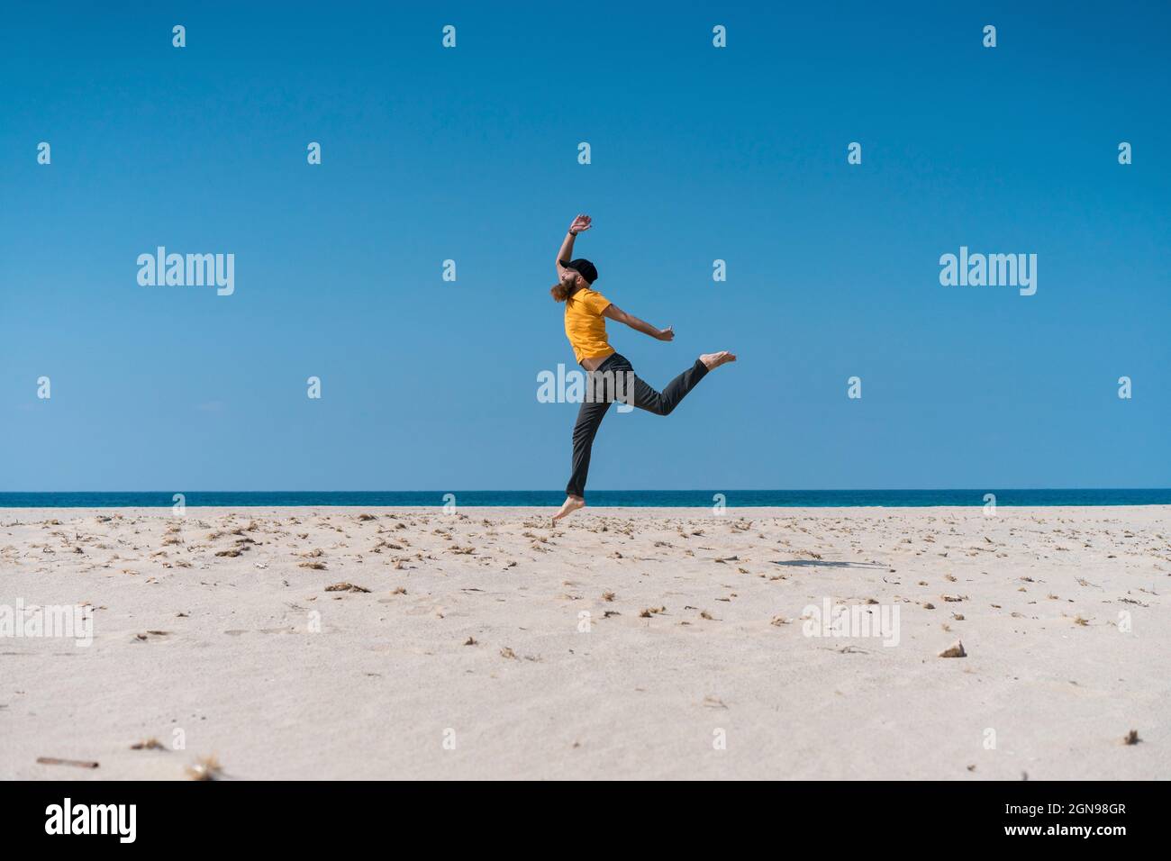 Homme insouciant qui court sur la plage Banque D'Images