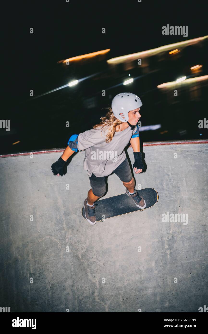 Homme avec casque de sport, skateboard au parc Banque D'Images