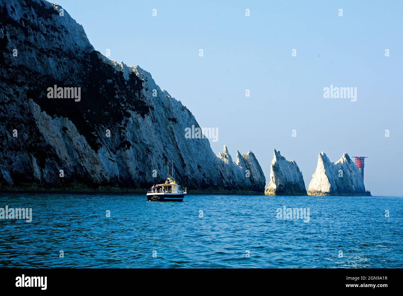 Les aiguilles et les falaises blanches sur l'île de Wight avec un petit bateau de pêche devant les falaises Banque D'Images