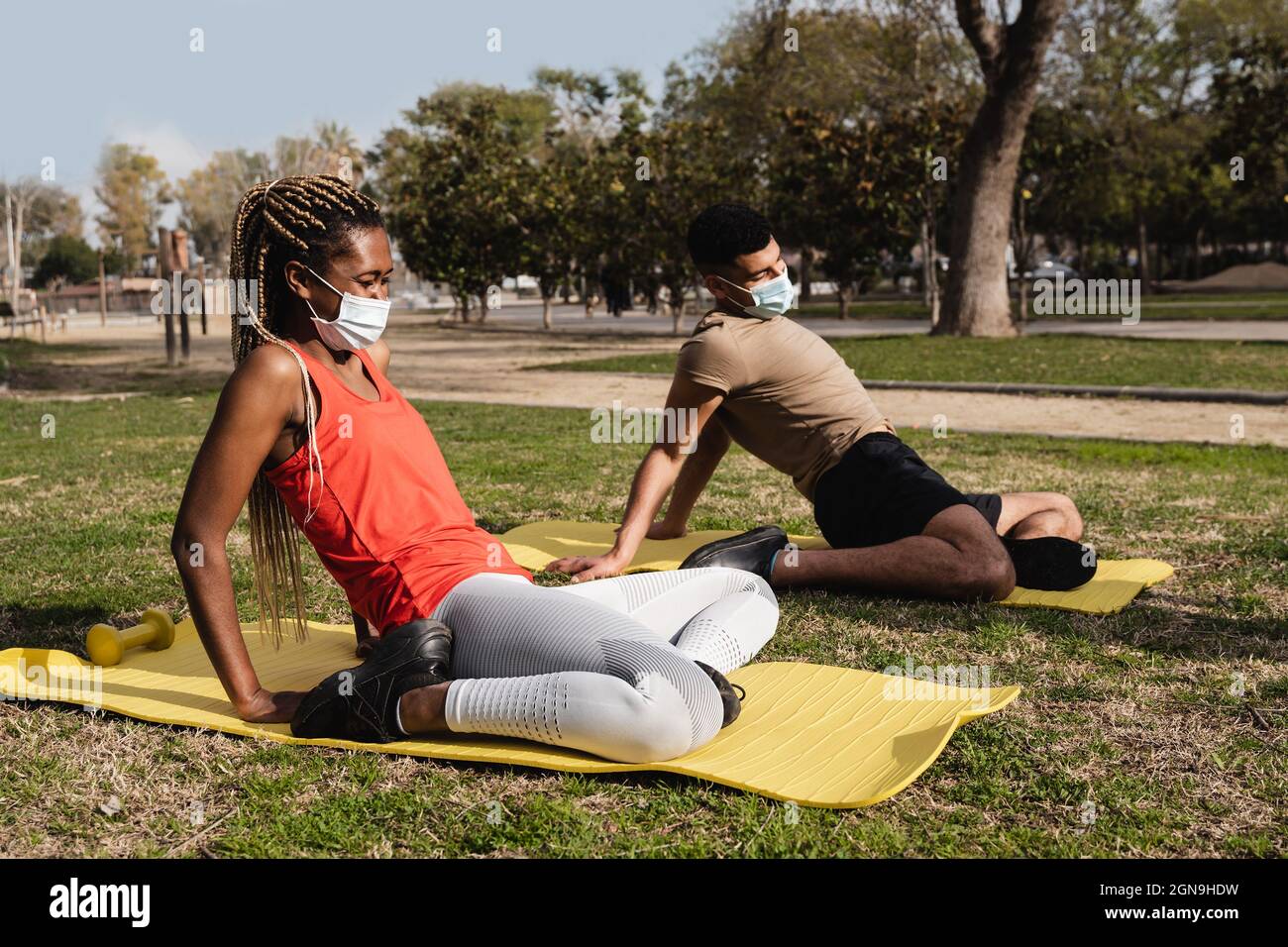 Les Noirs font le yoga routine en plein air tout en portant des masques de sécurité en plein air au parc de la ville - Focus sur le visage de fille africaine Banque D'Images