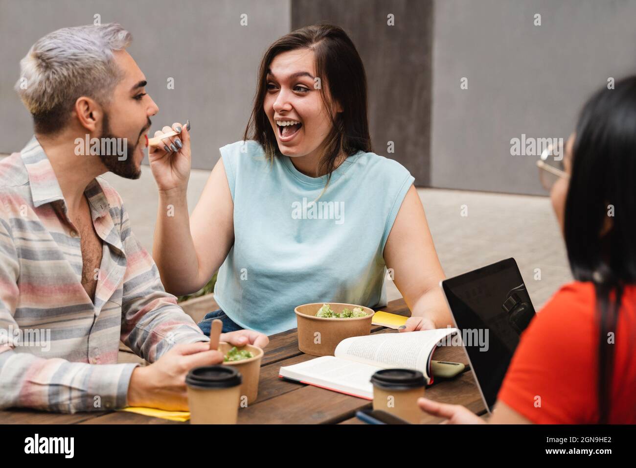 Les jeunes qui s'amusent à manger de la nourriture saine à emporter en plein air dans la ville - Focus sur le visage de la fille centrale Banque D'Images