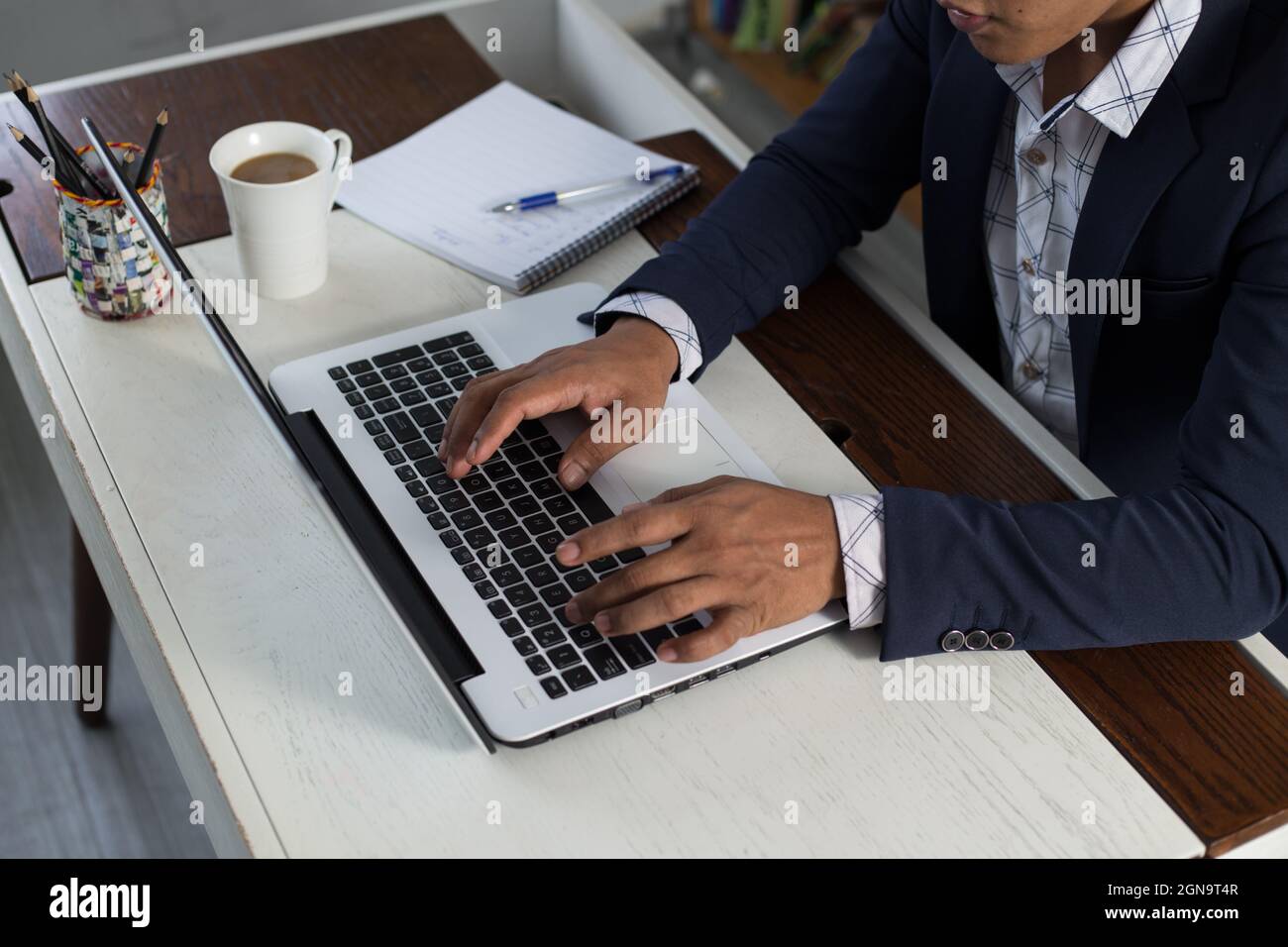 Employé d'entreprise adulte travaillant sur son ordinateur portable sur un bureau Banque D'Images