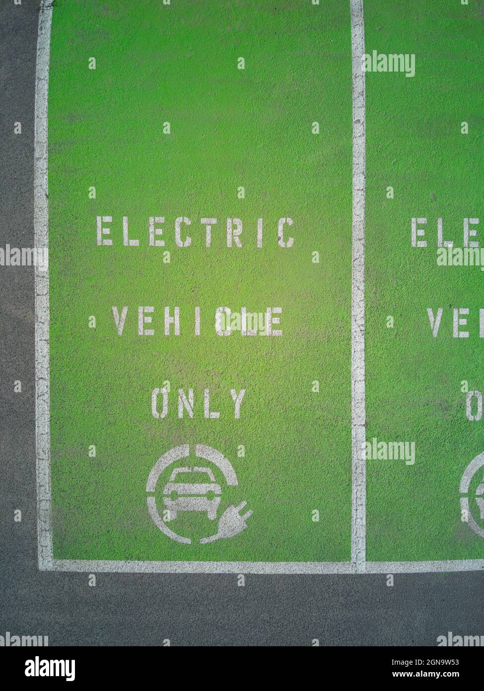 Symbole de charge de voiture électrique sur fond vert, branchez l'espace de stationnement du véhicule, Castlemaine, Victoria, Australie. Banque D'Images