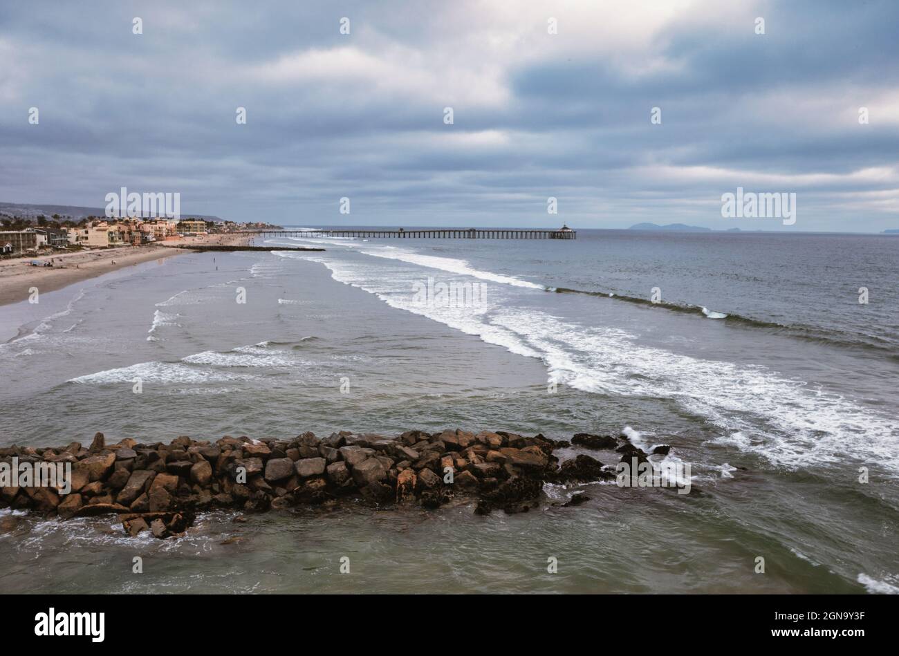 Tir de drone de faible altitude de la jetée en pierre avec jetée à distance, San Diego Californie Banque D'Images