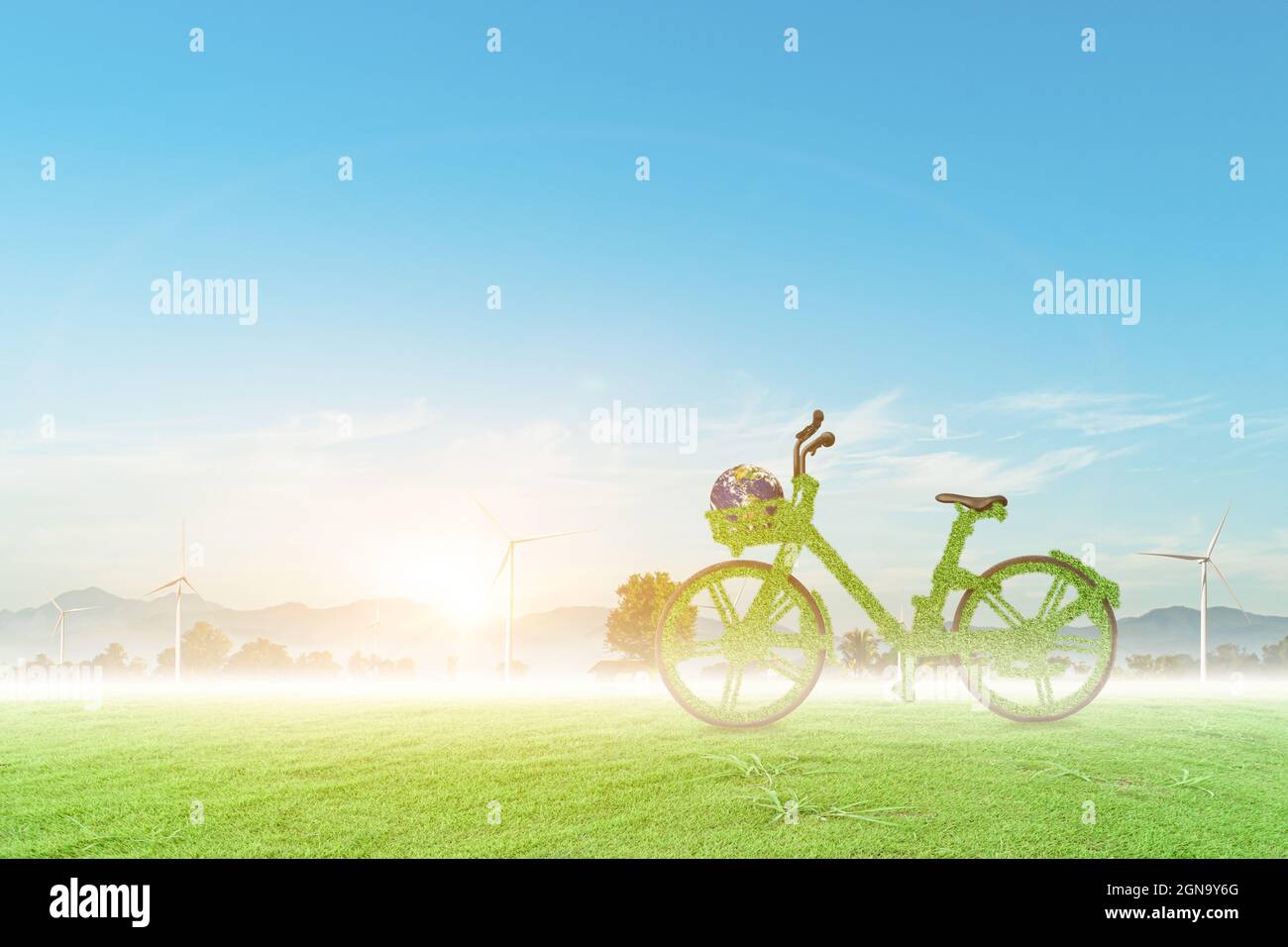 Vélo vert et globe sur le champ de l'éolienne avec fond bleu ciel. Concept écologique. Banque D'Images
