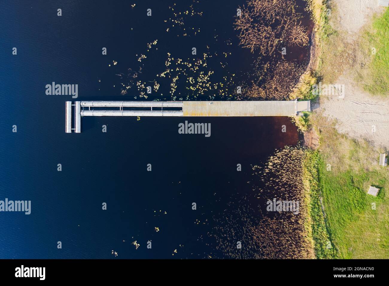 Une vue au-dessus d'un vieux quai par un lac en soirée d'automne. Certaines des planches de la jetée ont été enlevées pour l'hiver. Banque D'Images