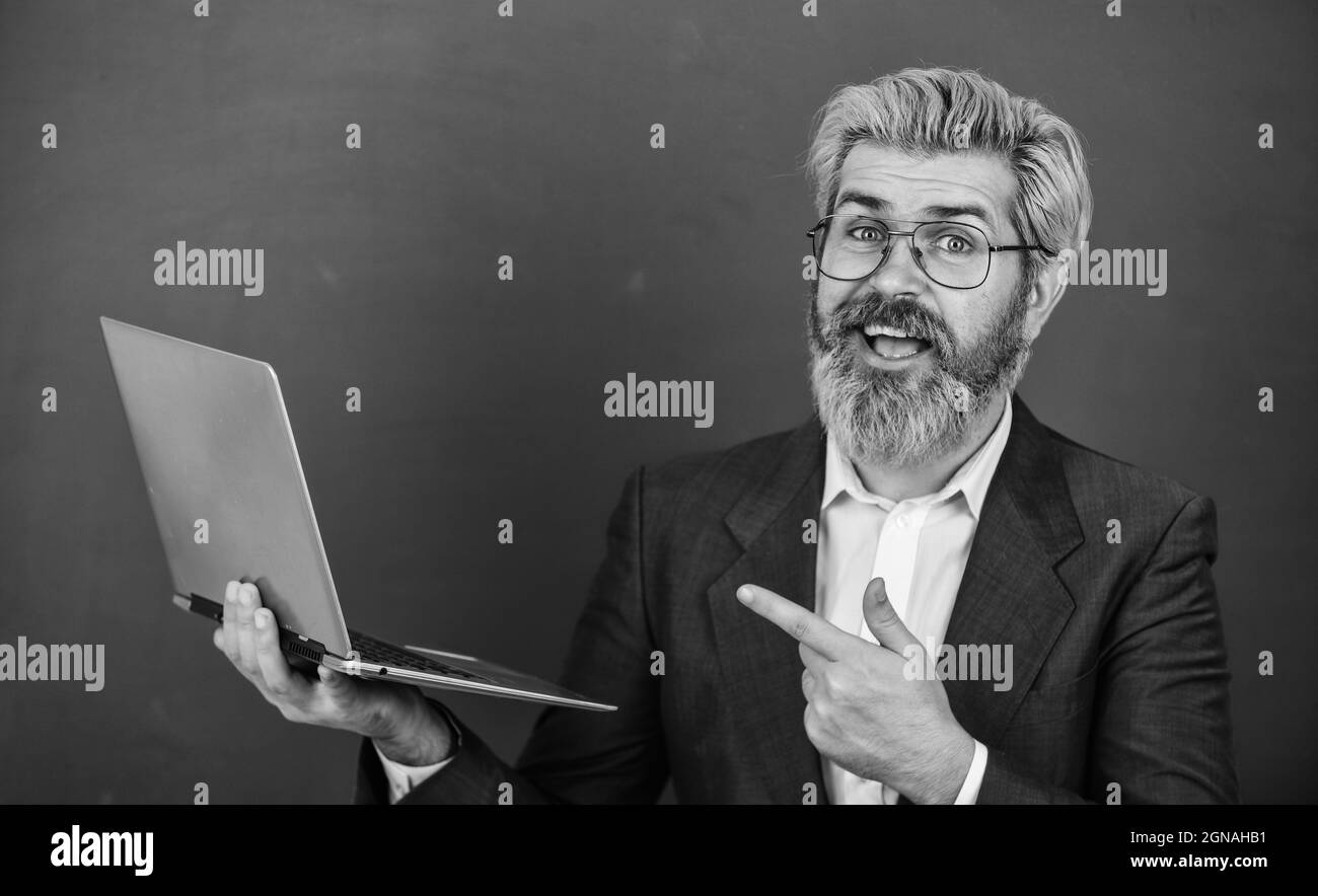 Fournir des informations à jour précises. Professeur porter lunettes tenir ordinateur portable surfer sur Internet. Homme barbu ordinateur portable moderne surfer sur Internet. Intéressant Banque D'Images