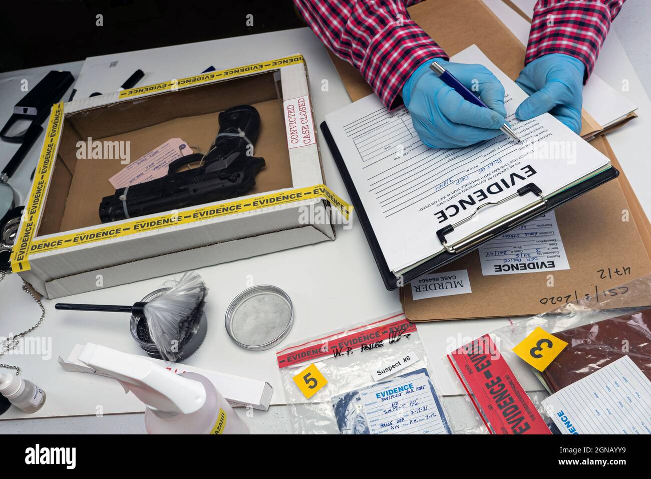 Gros plan de la boîte de preuves scientifiques médico-légales contenant une arme de la scène du crime, image conceptuelle Banque D'Images