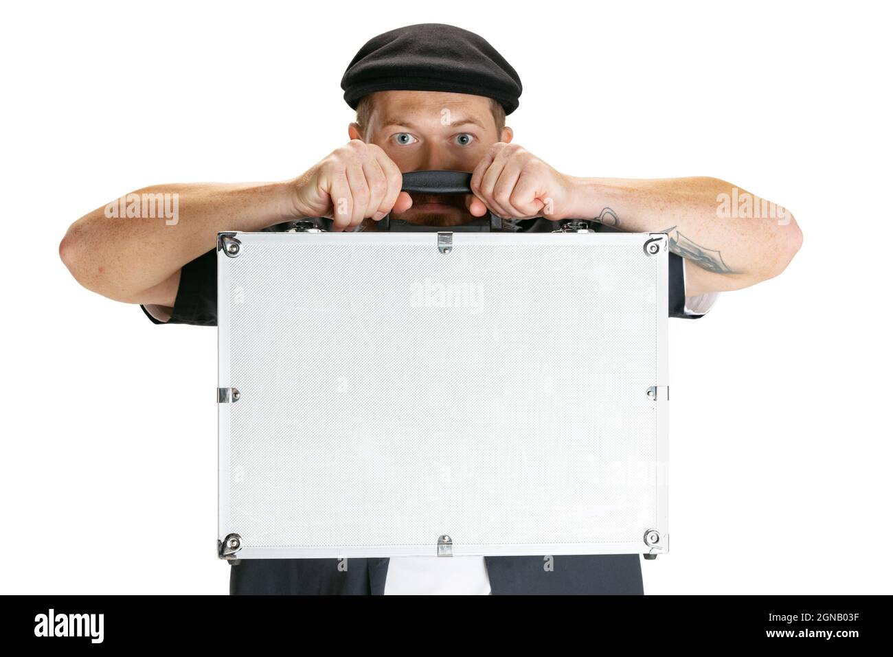 Gros plan d'un homme barbu, d'un coiffeur ou d'un coupe-cheveux élégant, isolé sur un arrière-plan studio blanc. Tenue d'une énorme valise grise avec équipement de travail. Banque D'Images