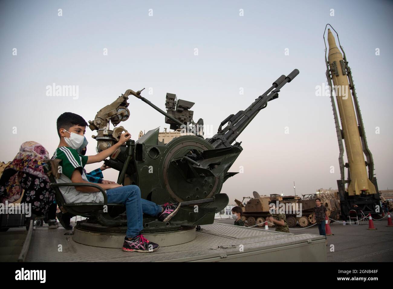 Téhéran, Iran. 23 septembre 2021. Un jeune garçon pose avec une arme anti-aérienne lors d'une exposition de guerre organisée par le corps des Gardiens de la révolution islamique (IRGC) dans un parc du sud de Téhéran pour marquer l'anniversaire de la guerre Iran-Irak (1980-88) le 23 septembre 2021. (Photo de Sobhan Farajvan/Pacific Press) crédit: Pacific Press Media production Corp./Alay Live News Banque D'Images