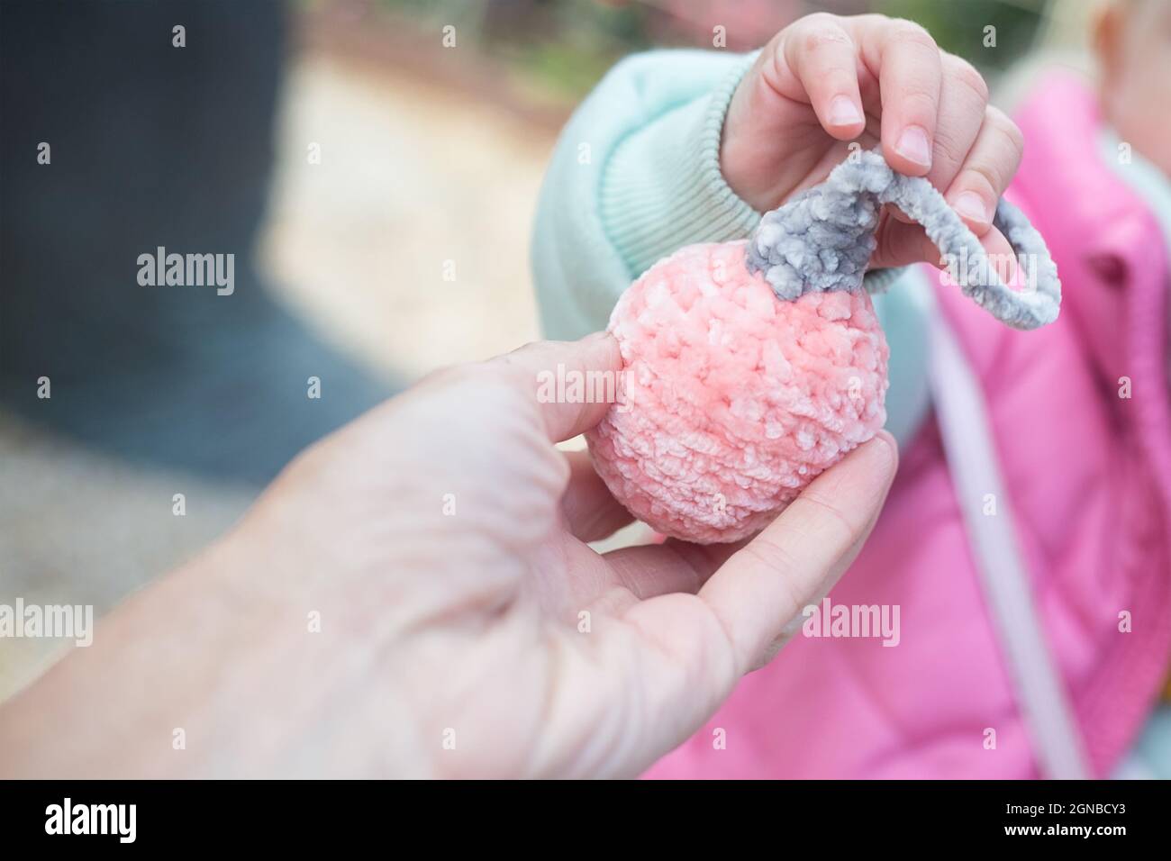 Mère donne à bébé nouvel an boule amigurumi.Tricoté en fil de peluche doux pour la décoration de Noël.Cadeaux de Noël faits main.Faire un cadeau Banque D'Images