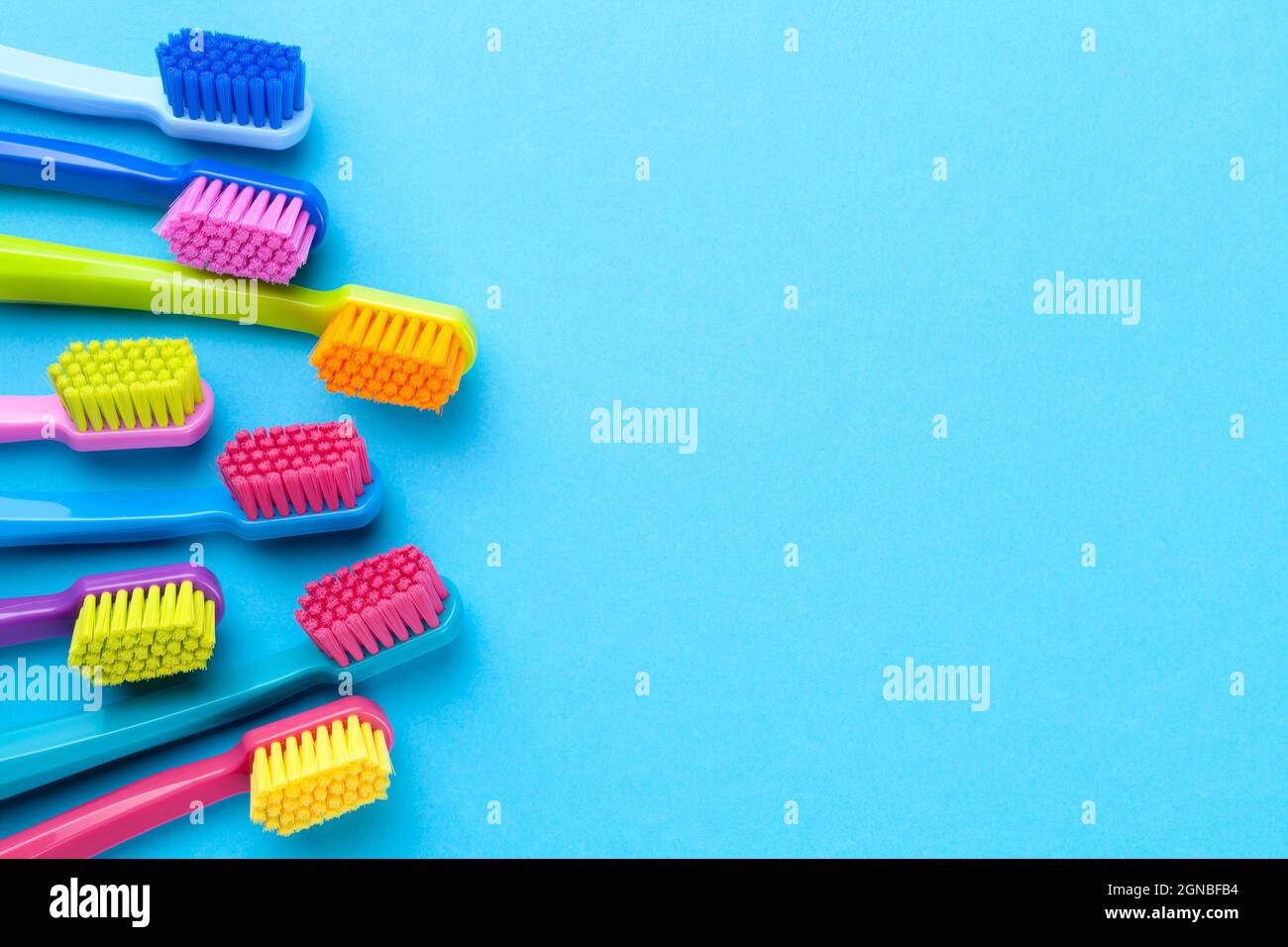 Brosses à dents colorées sur fond de papier bleu avec espace de copie. Vue de dessus Banque D'Images