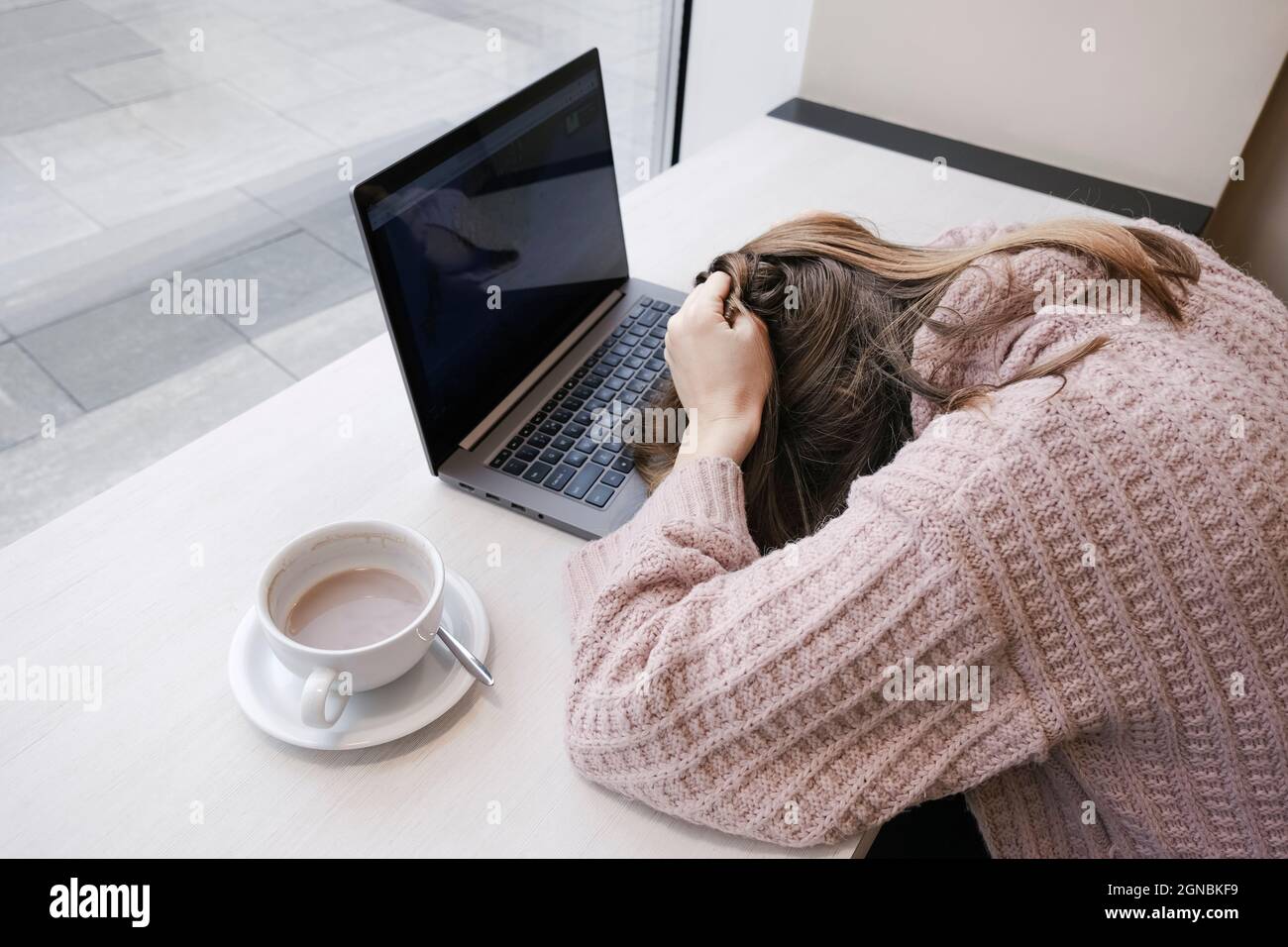 Une jeune femme fatiguée, employée de bureau, a mis sa tête sur le bureau. Concept d'épuisement professionnel des employés de bureau. Travail ou formation à partir de la bannière de la vue de dessus de collègue Banque D'Images