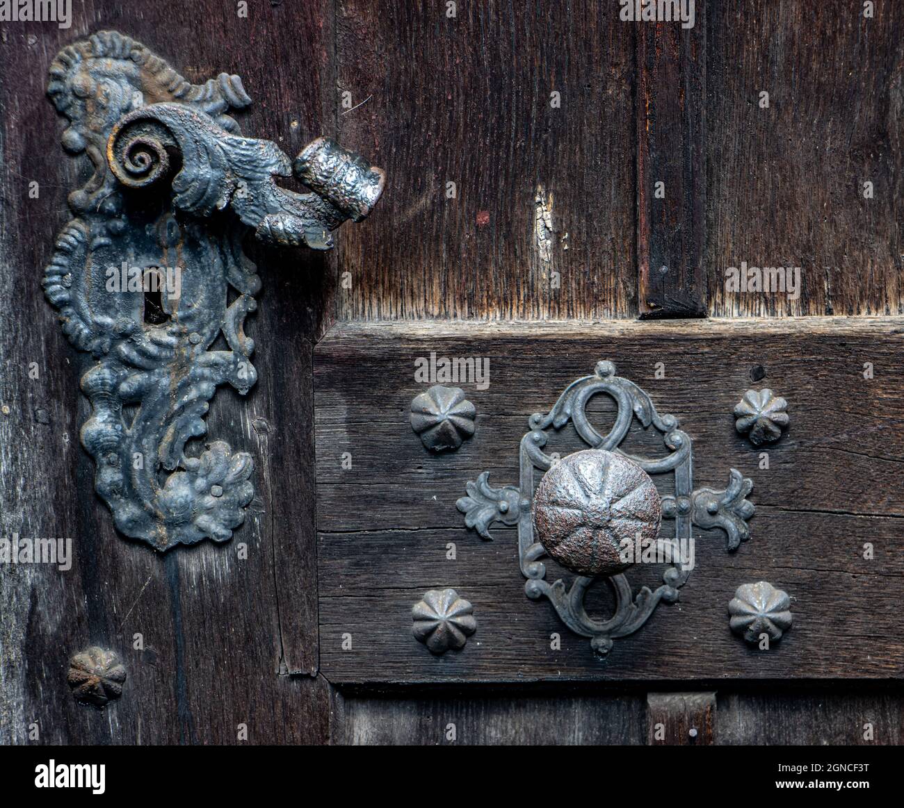 Une ancienne poignée en fer avec bouton de porte dans une porte historique, vue rapprochée Banque D'Images