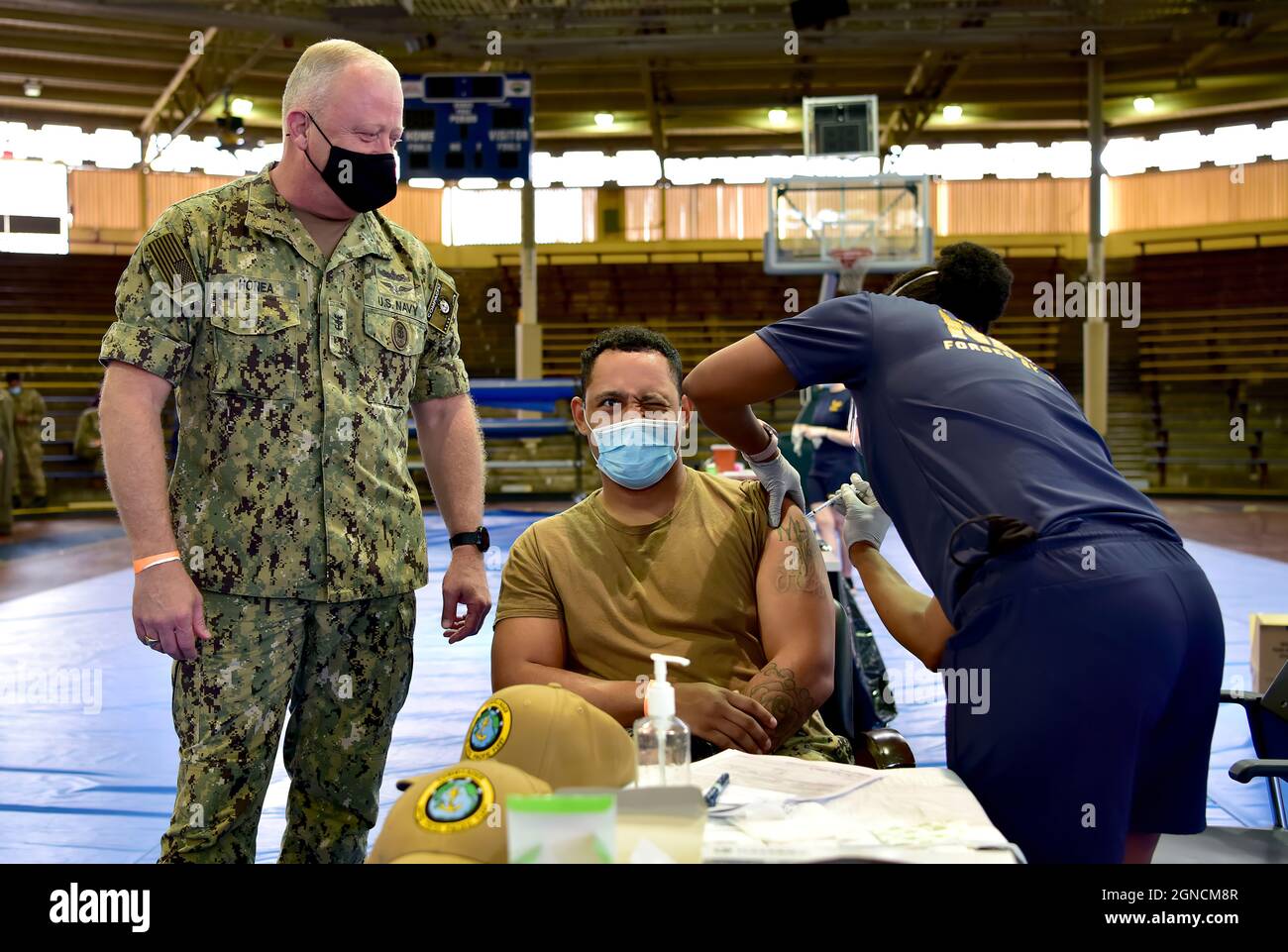 PEARL HARBOR, Hawaï (déc 29, 2020) Master-at-Arms 1re classe Patrick Moore reçoit le vaccin COVID-19 comme le chef de la flotte du Pacifique des États-Unis James Honea observe à la base conjointe Pearl Harbor-Hickam, le 29 décembre 2020. La clinique de santé navale d'Hawaii a été l'un des établissements choisis pour recevoir le vaccin dans le cadre d'une stratégie coordonnée et progressive, en donnant la priorité au vaccin pour le personnel admissible afin de protéger sa santé, sa famille et sa communauté. (É.-U. Photo de la Marine par Jay C. Pugh, spécialiste en communications de masse, 201229-N-YU572-0086 Banque D'Images