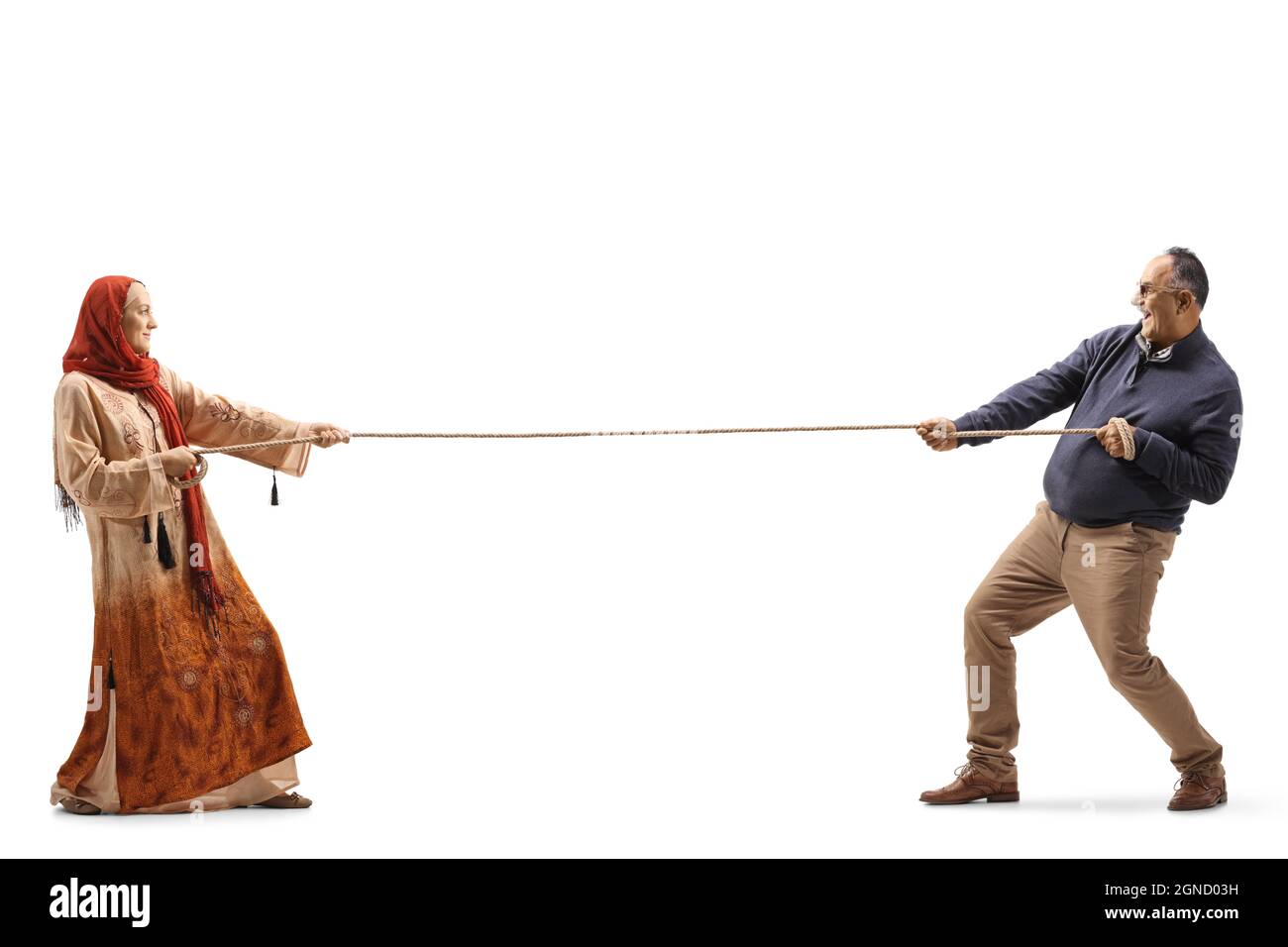 Photo pleine longueur d'une femme portant un hijab et d'un homme mature tirant une corde isolée sur fond blanc Banque D'Images