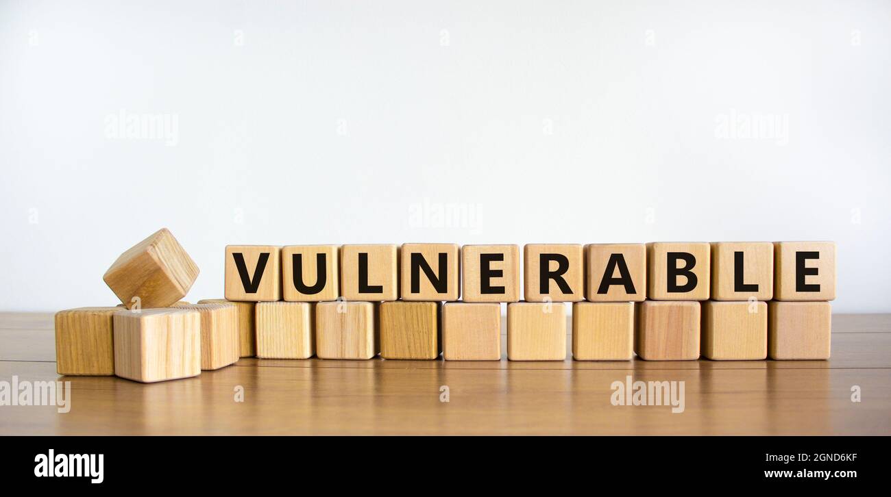 Symbole vulnérable. Le mot vulnérable sur les cubes en bois. Belle table en bois, fond blanc. Concept d'entreprise et de vulnérabilité. Copier l'espace. Banque D'Images