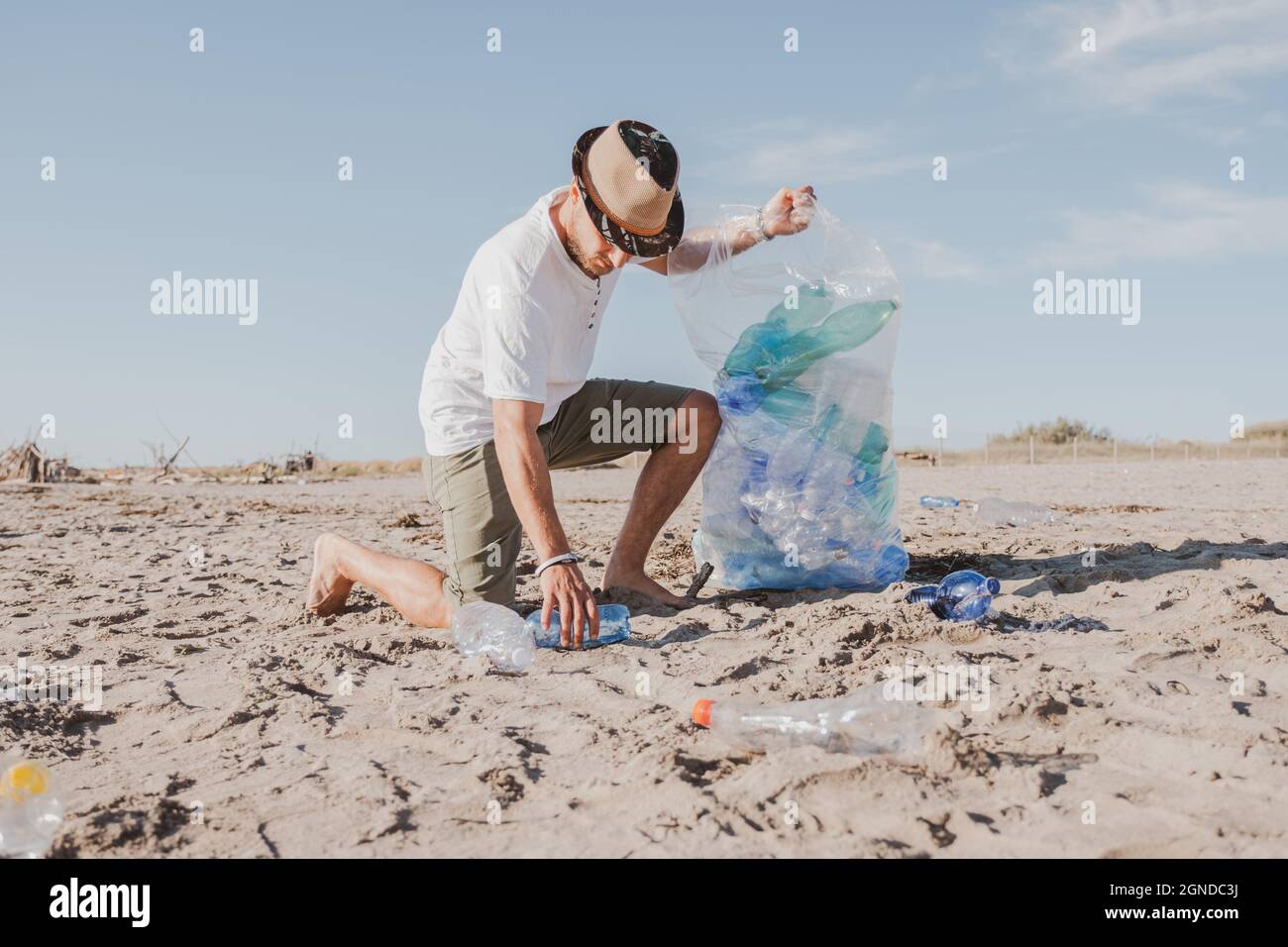 Groupe d'amis activistes collectant des déchets plastiques sur la plage. Les gens nettoyant la plage, avec des sacs. Concept de conservation de l'environnement et de l'océan Banque D'Images