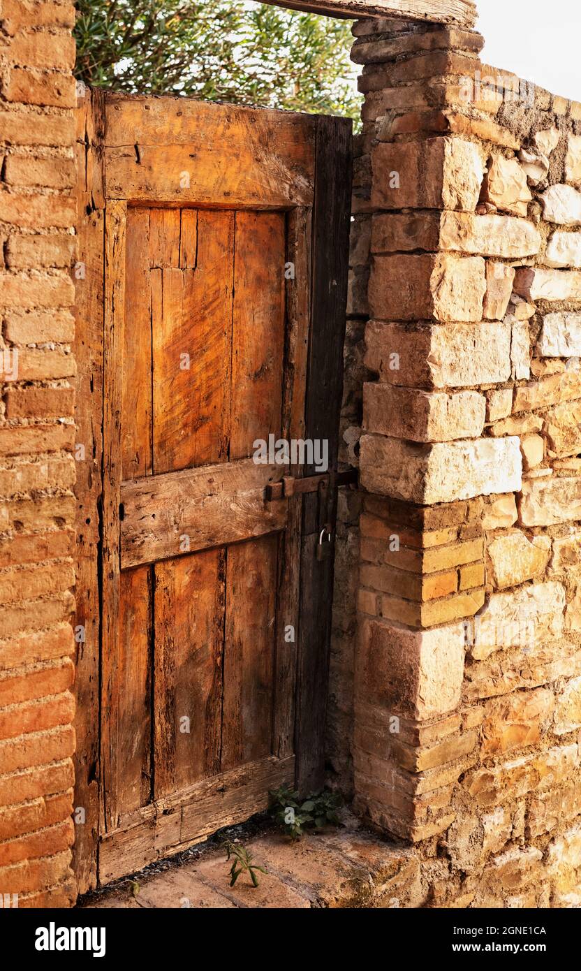 Vieille porte en bois abîmée fermée, mur de pierre en ruines Photo Stock -  Alamy