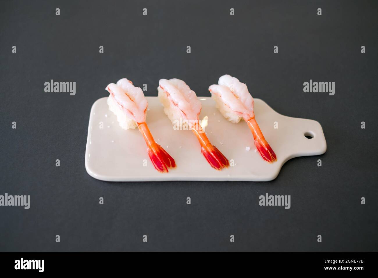 Sushis aux crevettes dans le restaurant japonais. Sushi - ama EBI Nigiri sur tableau blanc isolé sur fond noir. Sushis aux crevettes. Photo de haute qualité Banque D'Images
