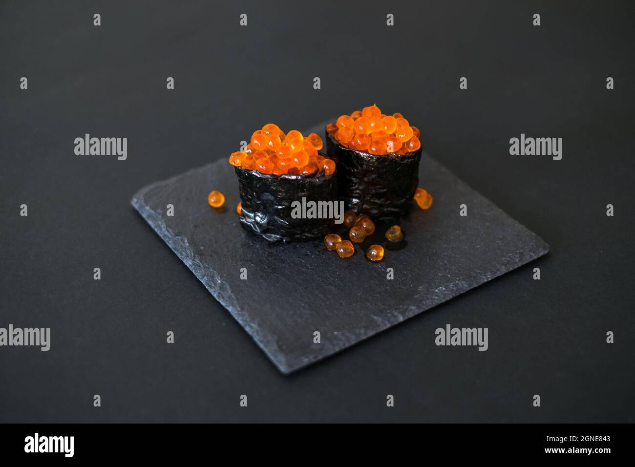 Gunkan Maki avec caviar de saumon servi au restaurant sur le tableau noir. Isolé sur fond noir. Cuisine traditionnelle japonaise. Photo de haute qualité Banque D'Images