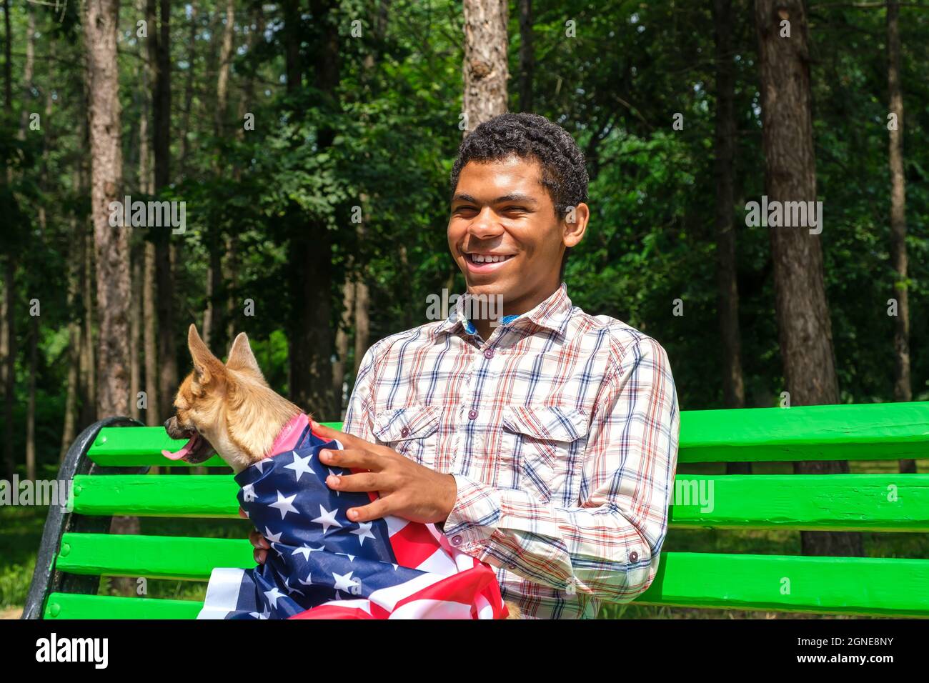 Homme afro-américain souriant avec un chien détendu sur le banc Banque D'Images
