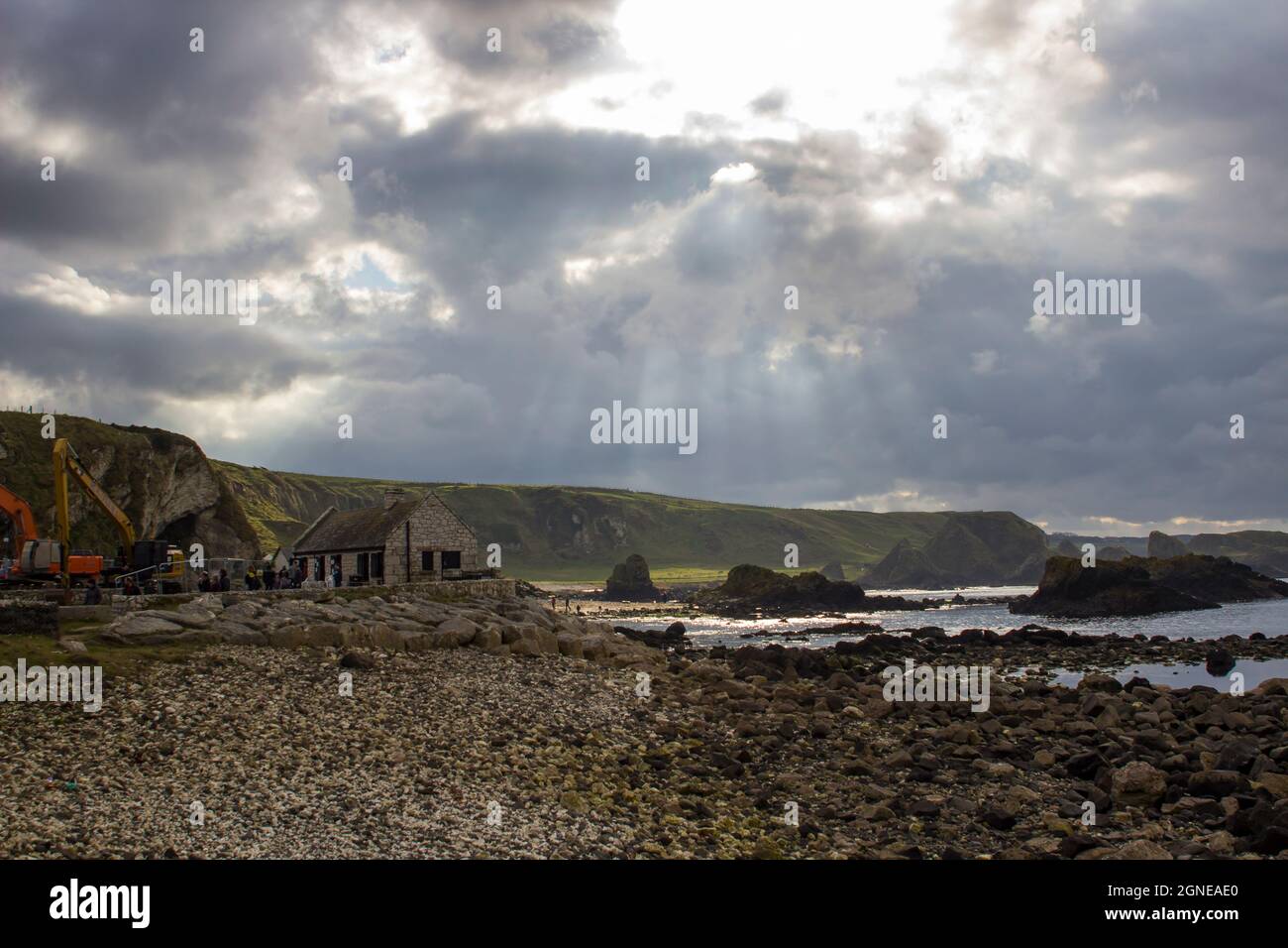 Le soleil se brise à travers des nuages sombres au-dessus du port de Ballintoy dans le comté d'Antrim en Irlande du Nord, lors d'une journée de débordement en 2017 Banque D'Images