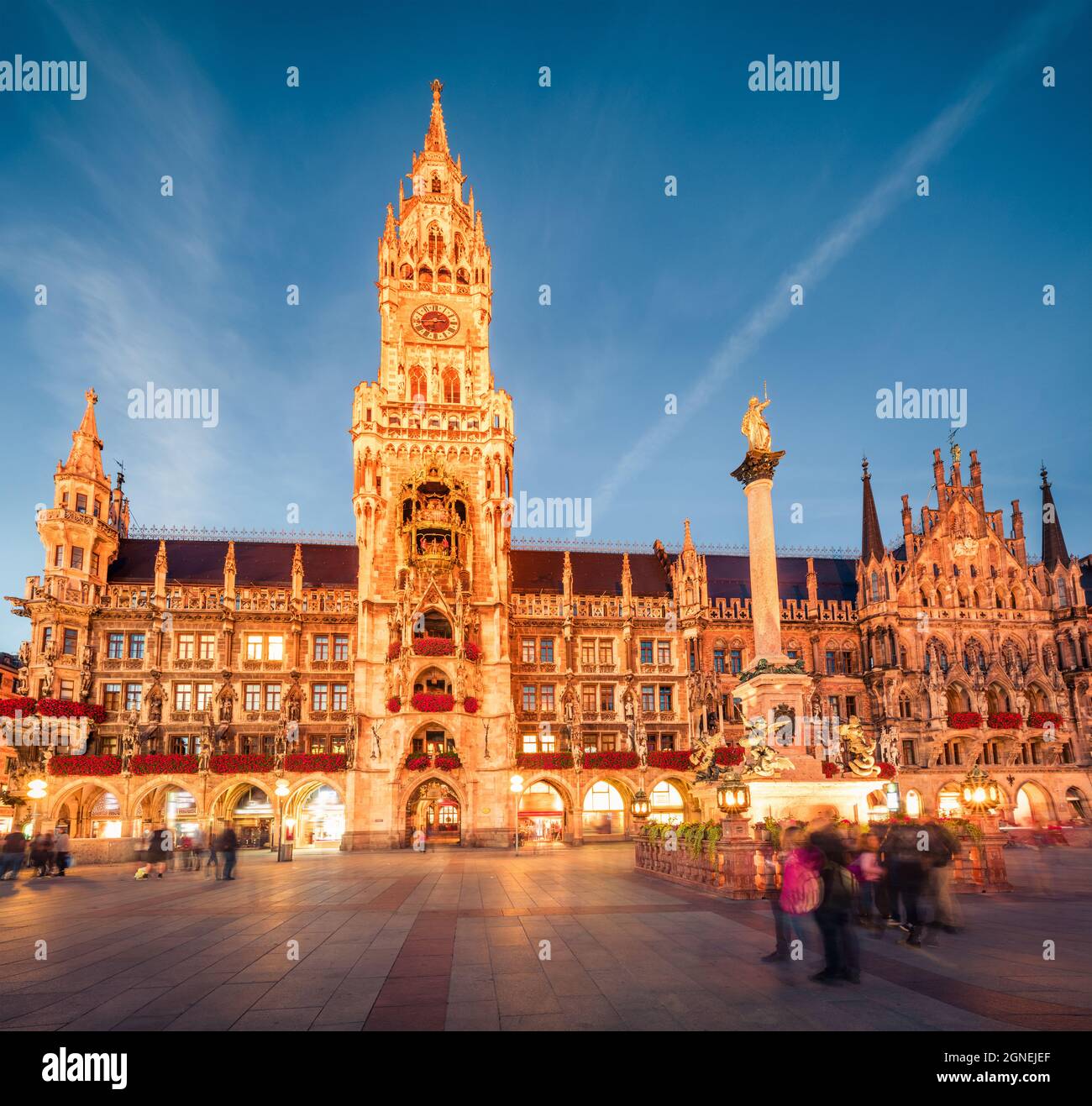 Vue impressionnante en soirée sur Marienplatz - place du centre-ville et centre de transport avec l'imposante église Saint-Pierre, deux halls de ville et un musée du jouet, Munich, Banque D'Images