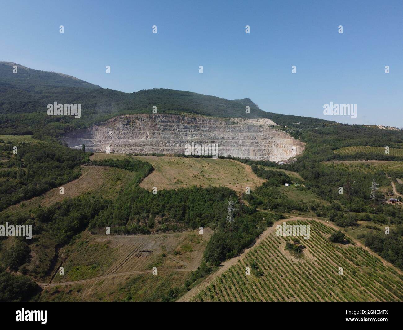 Vue aérienne industrielle d'une carrière d'exploitation minière en obât avec beaucoup de machines en travail - pierre concassée et matériaux de construction pour l'industrie de l'interprétation Banque D'Images