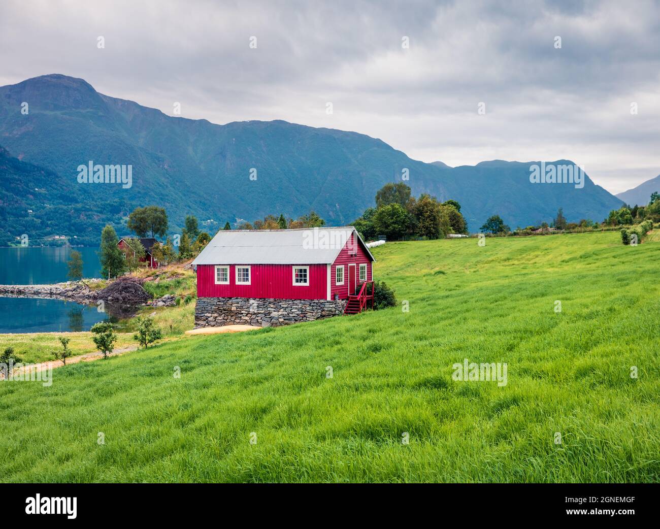 Campagne typique paysage norvégien avec maison murale peinte en rouge. Matin d'été nuageux en Norvège, Europe. Beauté de la nature concept fond. Art Banque D'Images
