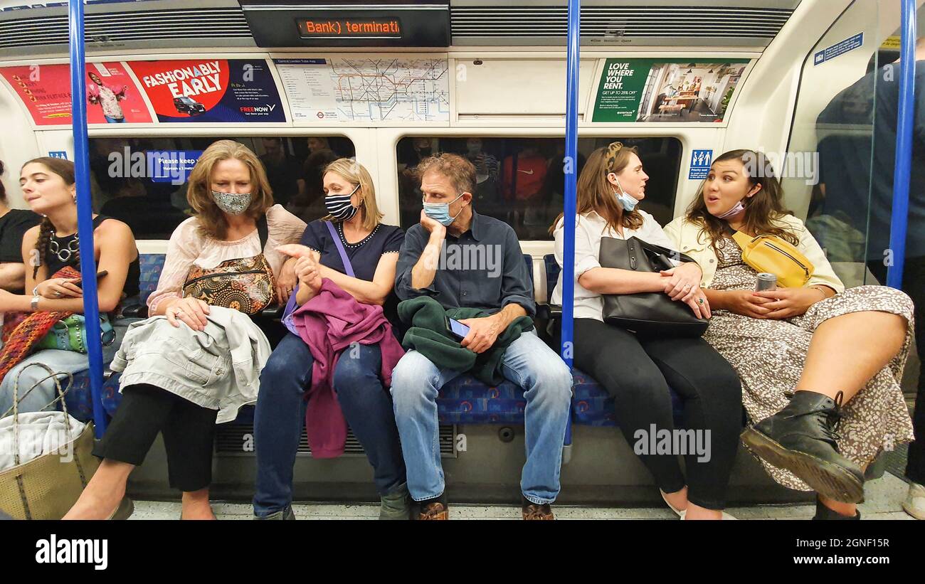 Londres, Royaume-Uni, 24 septembre 2021 : dans une rangée de sièges sur une ligne de transport Northern Line, en début de vendredi soir, moins de la moitié des passagers portent un masque ou un couvre-visage. Les règles de transport pour Londres exigent que les passagers portent un masque à moins qu'ils ne soient médicalement exemptés, mais les règles sont largement ignorées. Les décès de personnes avec des covid sont actuellement autour de 1000 personnes par semaine. Les nouveaux numéros de cas sont élevés mais ont récemment chuté et le nombre R semble être autour de 1. Anna Watson/Alay Live News Banque D'Images