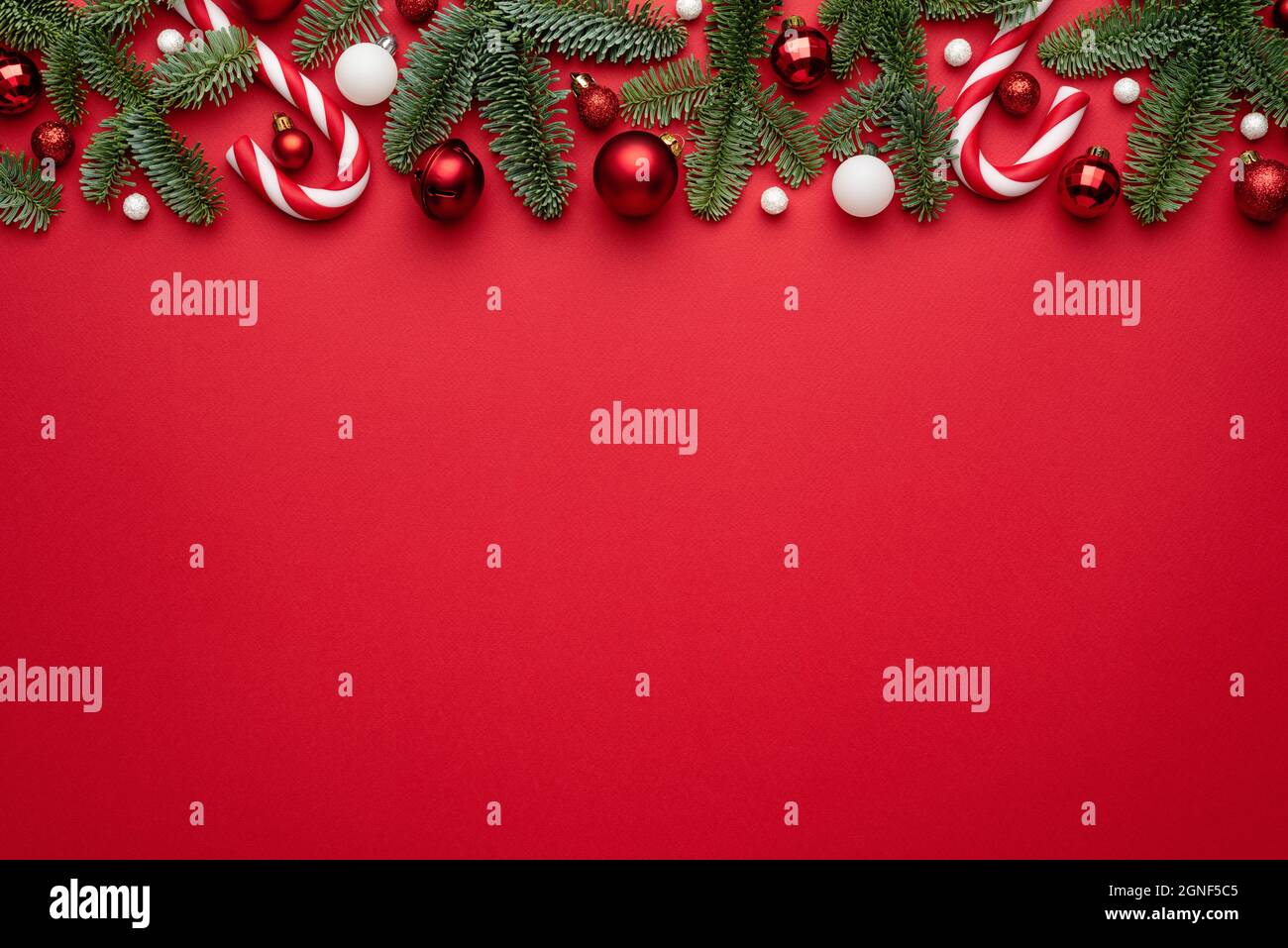 Fond rouge avec décorations de Noël en branches de sapin et boules de Noël. Vide avec un espace de copie pour le texte Banque D'Images