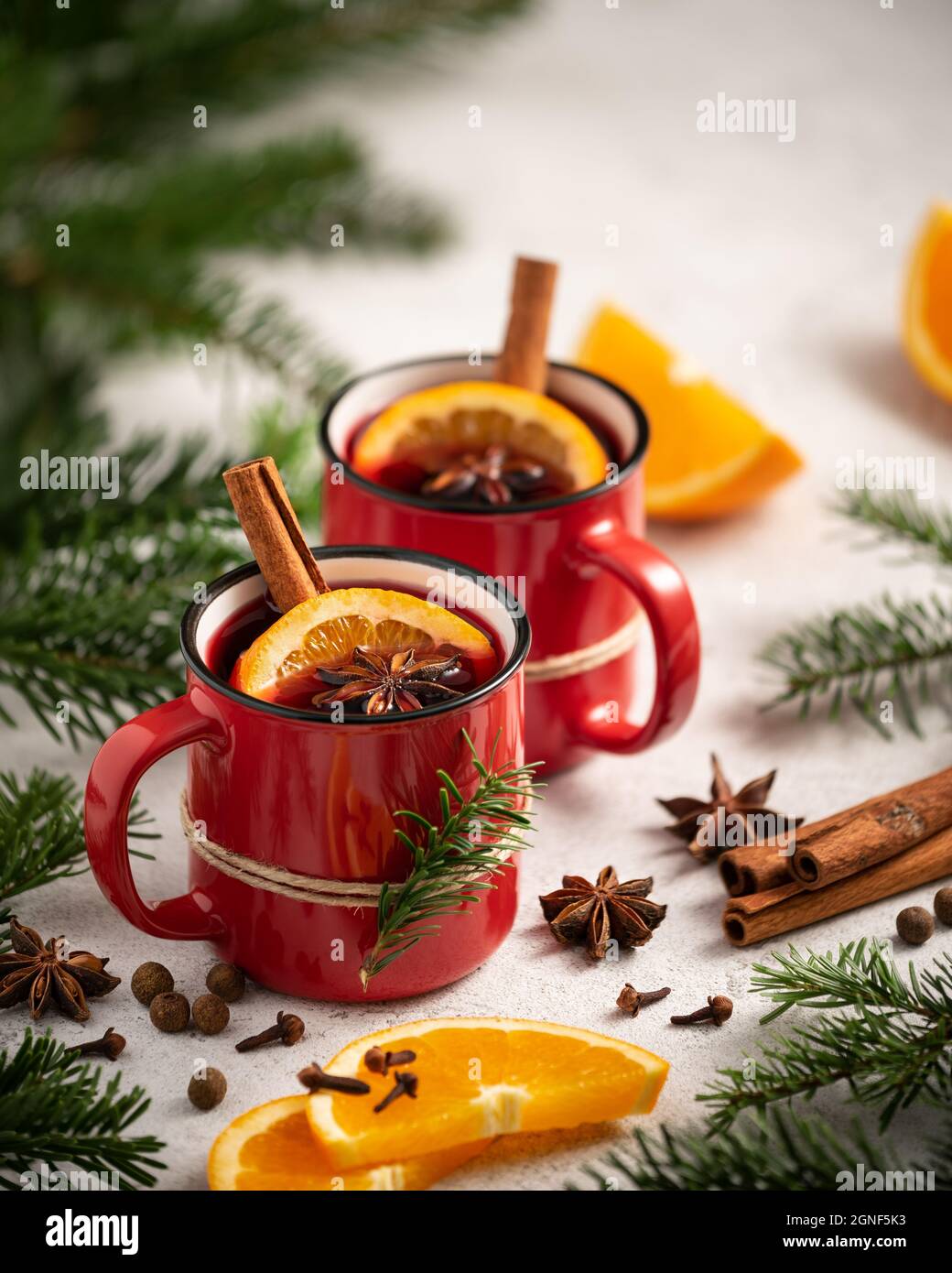 Carte de Noël avec vin chaud, épices et oranges entourées de branches de sapin Banque D'Images