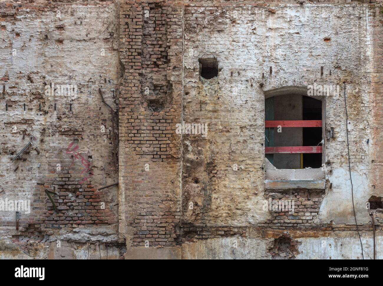 Mur en brique rouge cassé et plâtre endommagé sur l'arrière-plan Banque D'Images