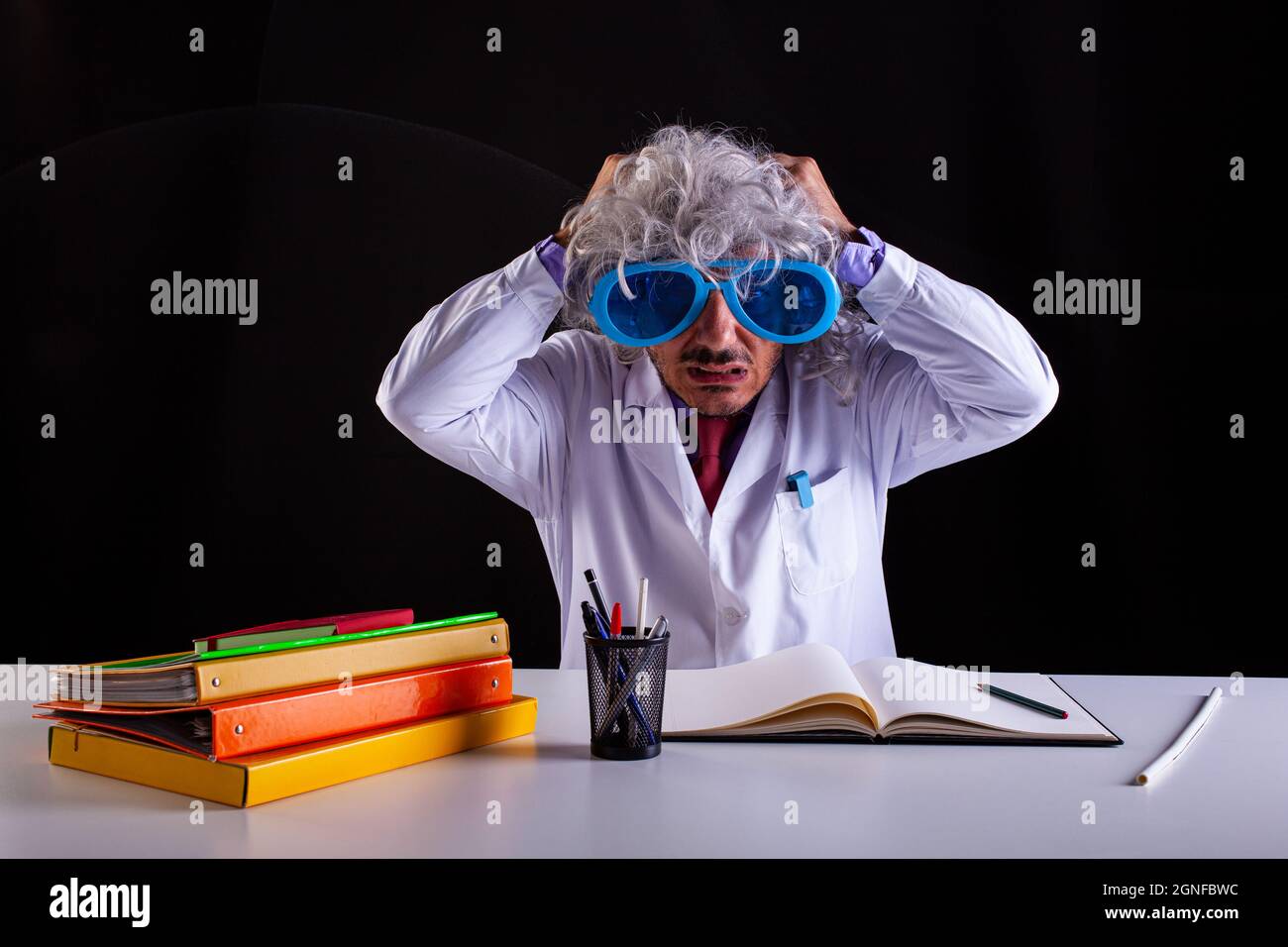 Professeur de sciences en manteau blanc désespéré en manteau blanc met ses mains sur ses cheveux Banque D'Images