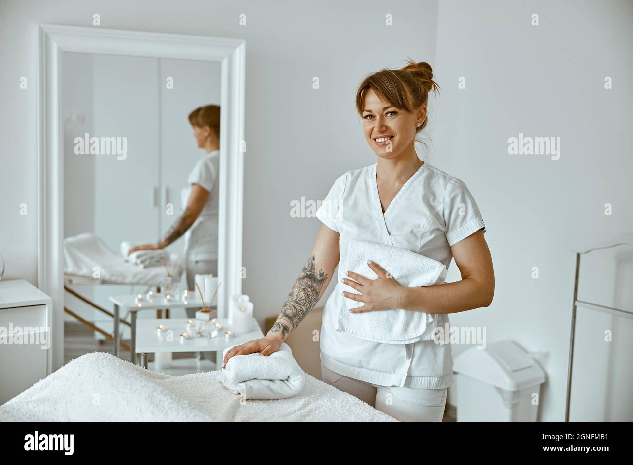 belle femme caucasienne heureuse pose dans blanc minimaliste moderne salon de traitement Banque D'Images
