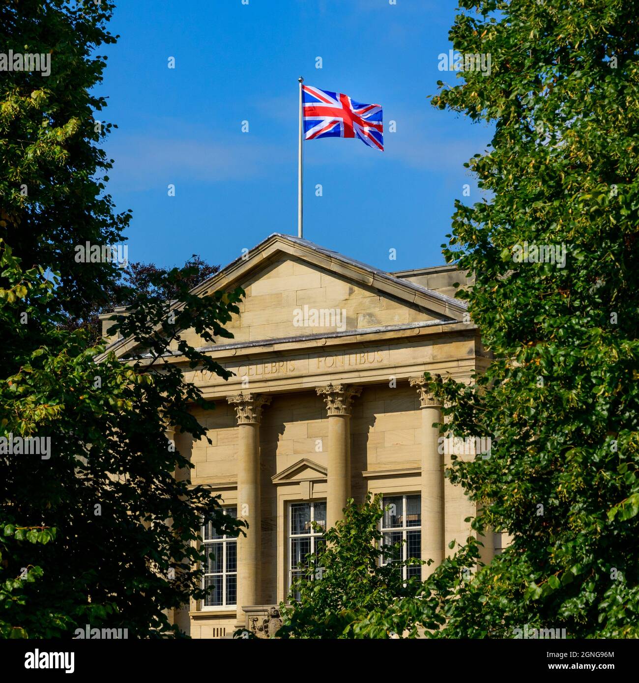 Drapeau Union Jack survolant les bureaux éclairés du Conseil d'Harrogate (devise latine, extérieur du bâtiment, ciel bleu profond) - Crescent Gardens, Yorkshire England, Royaume-Uni Banque D'Images