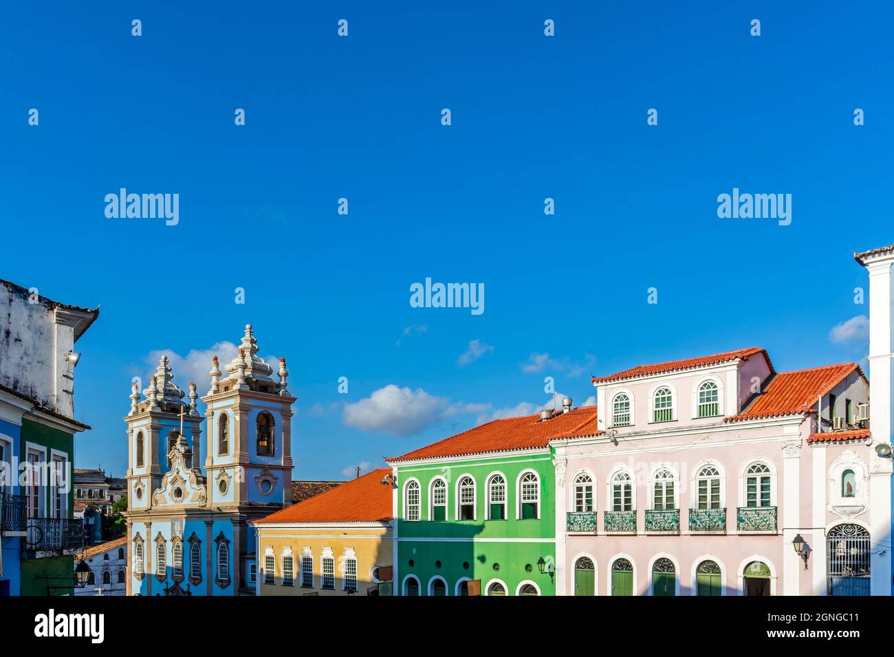 Façades de maisons colorées et tour d'une ancienne église baroque à Pelourinho, le célèbre centre historique de Salvador, Bahia Banque D'Images