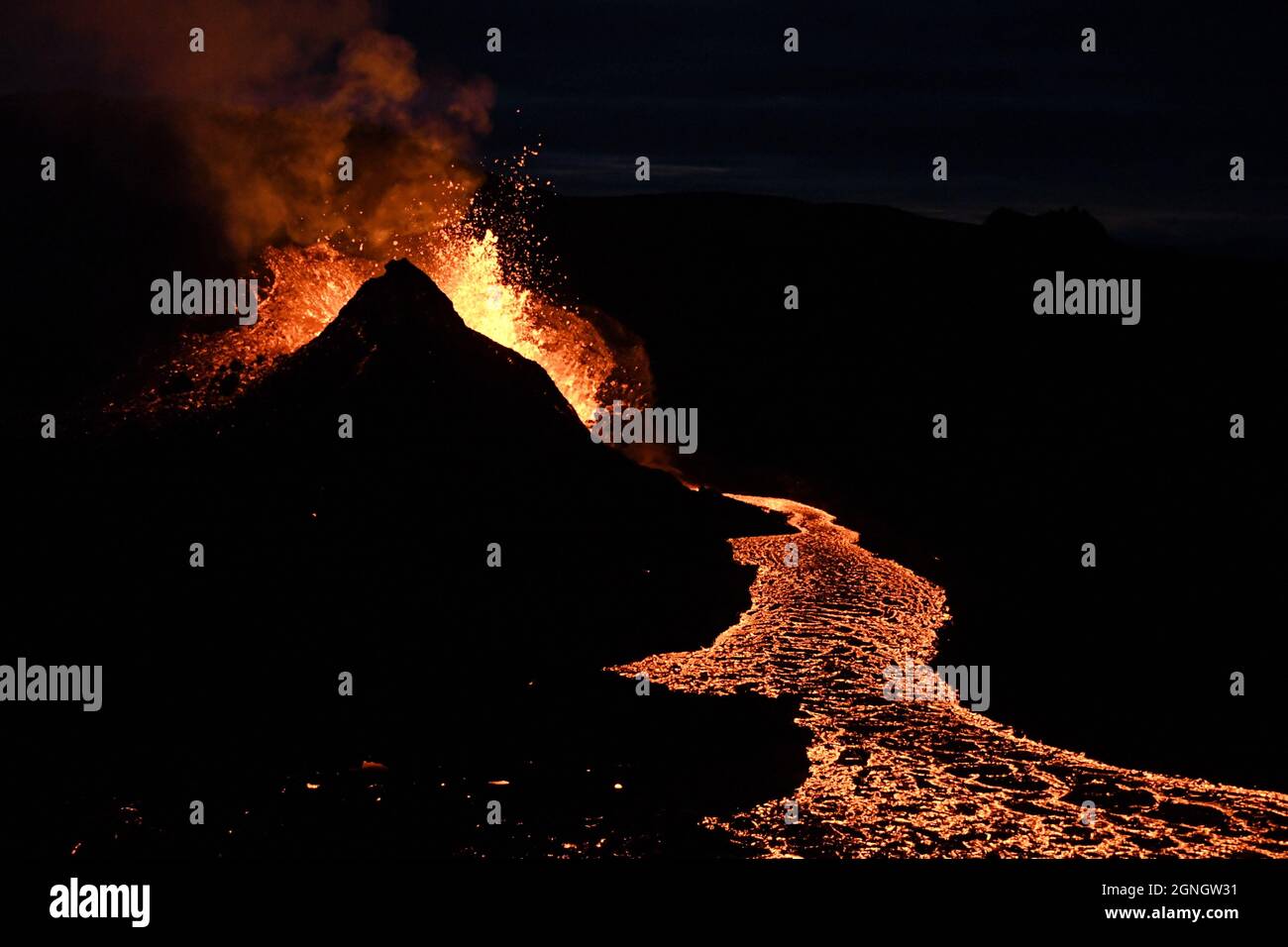 Éruption à Faggadalsfjall, Islande, la nuit. Isolé sur fond noir. La lave incandescente éclate d'un cratère volcanique, coulées de lave en premier plan. Banque D'Images