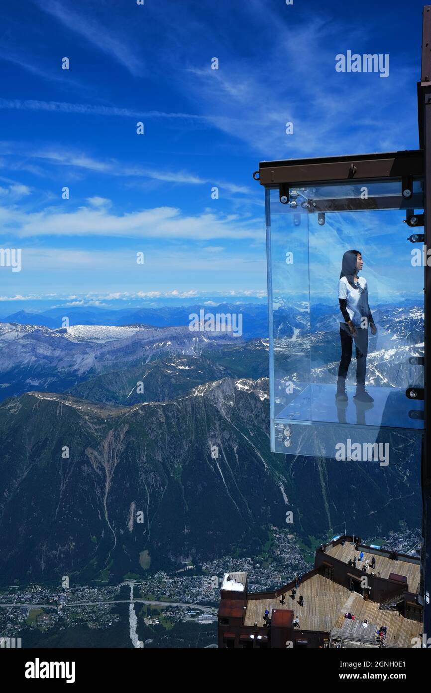 Un touriste se trouve dans le 'Step dans le Vide' boîte de verre sur l' Aiguille du Midi (3842 m) sommet de montagne au-dessus de Chamonix  Mont-Blanc Photo Stock - Alamy
