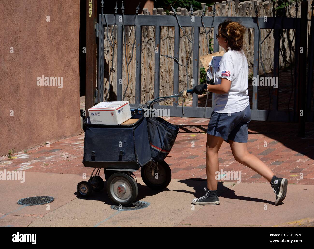 Un travailleur postal livre le courrier et les colis dans le centre-ville de Santa Fe, au Nouveau-Mexique. Banque D'Images