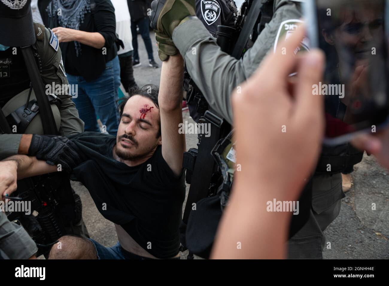 Des policiers israéliens et des soldats de la patrouille frontalière des FDI ont arrêté des manifestants israéliens pour avoir agité des drapeaux palestiniens lors de la manifestation de solidarité hebdomadaire à Sheikh Jarrah. Bien que le ministre de la sécurité intérieure ait ordonné à la police d'arrêter la confiscation violente il y a un mois, les ordonnances ne sont pas appliquées sur le terrain. Le manifestant a été traité dans une salle d'urgence en raison d'une blessure à la tête. Jérusalem, Israël. 24 septembre 2021. Credit: Matan Golan/Alay Live News Banque D'Images