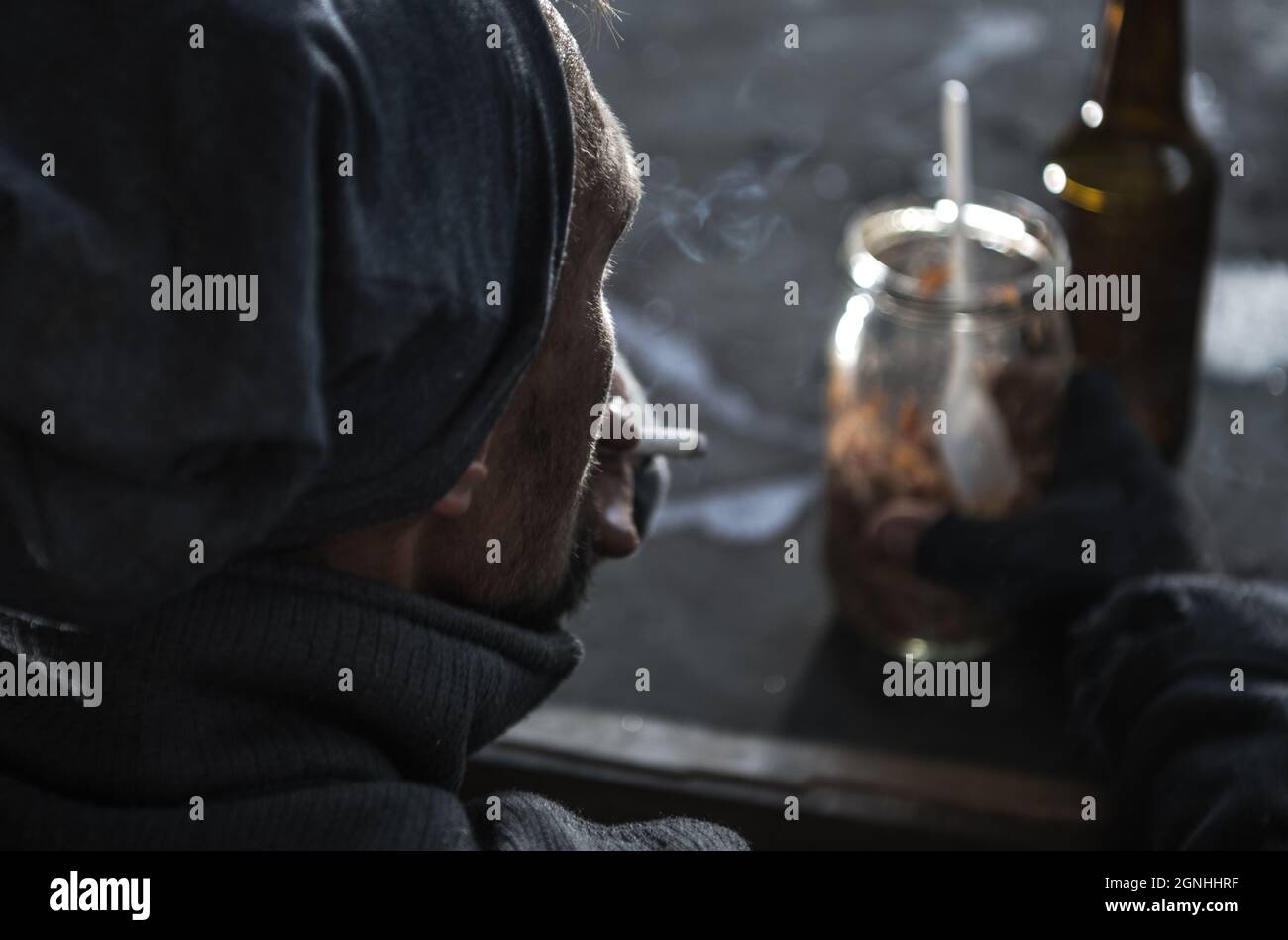 Sans-abri Caucasiens hommes dans ses 40 fumer une cigarette. Thème des questions sociales. Banque D'Images