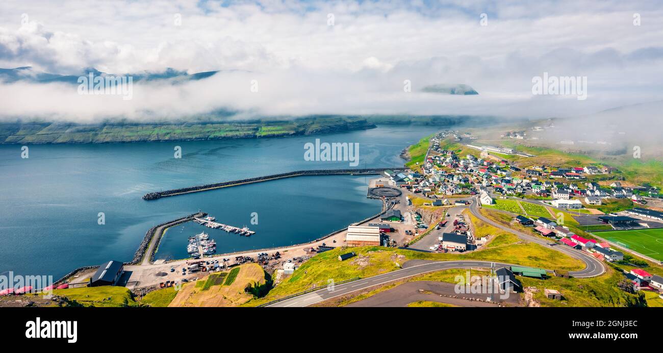 Vue depuis un drone volant. Paysage urbain brumeux de la ville d'Eidi. Vue d'été panoramique sur l'île d'Eysturoy. Paysage marin lumineux de l'océan Atlantique, îles Féroé Banque D'Images