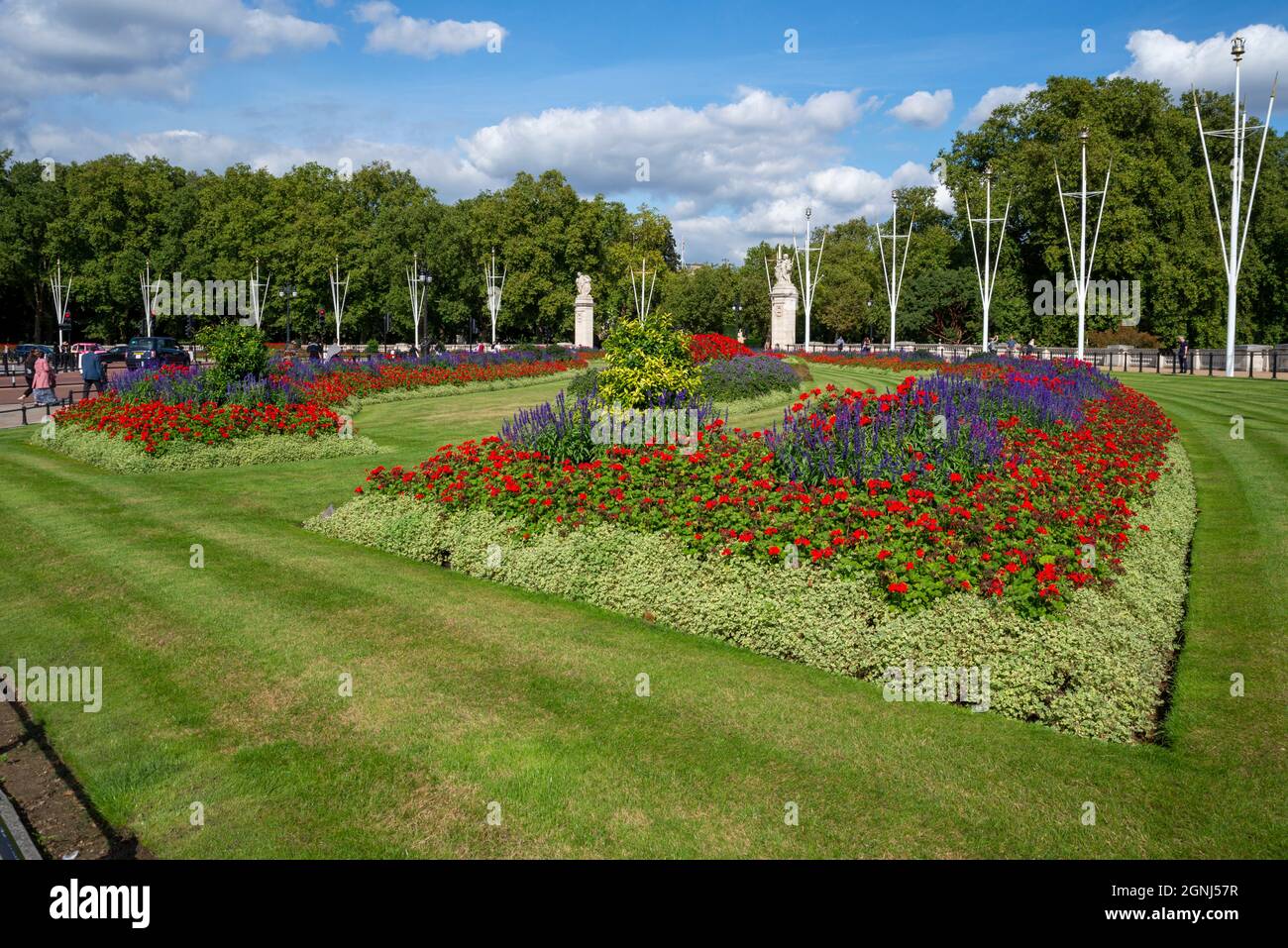 Buckingham Palace Memorial Gardens, le long du Mall, à Londres, Royaume-Uni. Pelouse tondue et bien entretenue autour des massifs fleuris Banque D'Images
