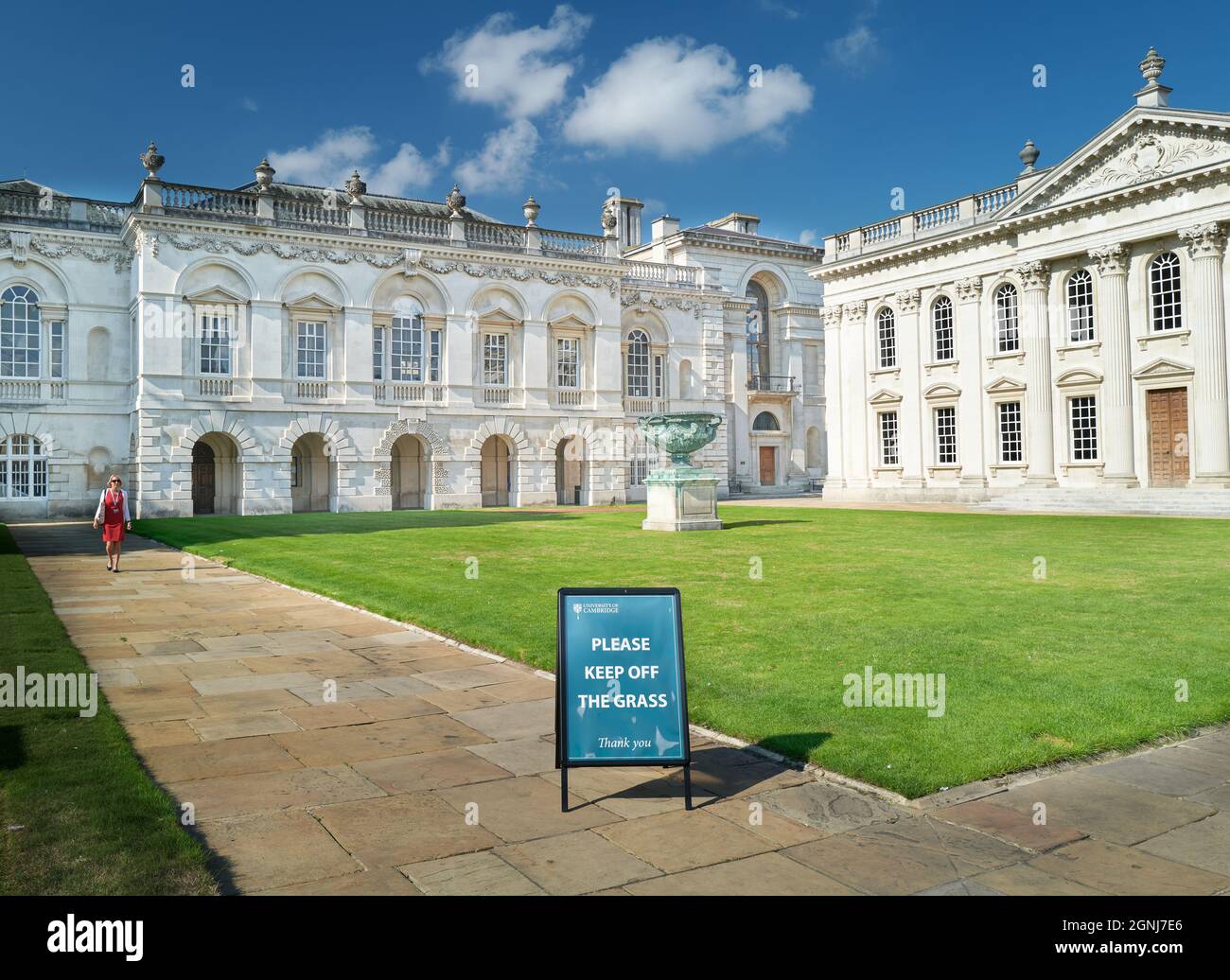 Une femme marche le long du chemin de la cour dans le bâtiment Old Schools et le Sénat de l'université de Cambridge, en Angleterre. Banque D'Images